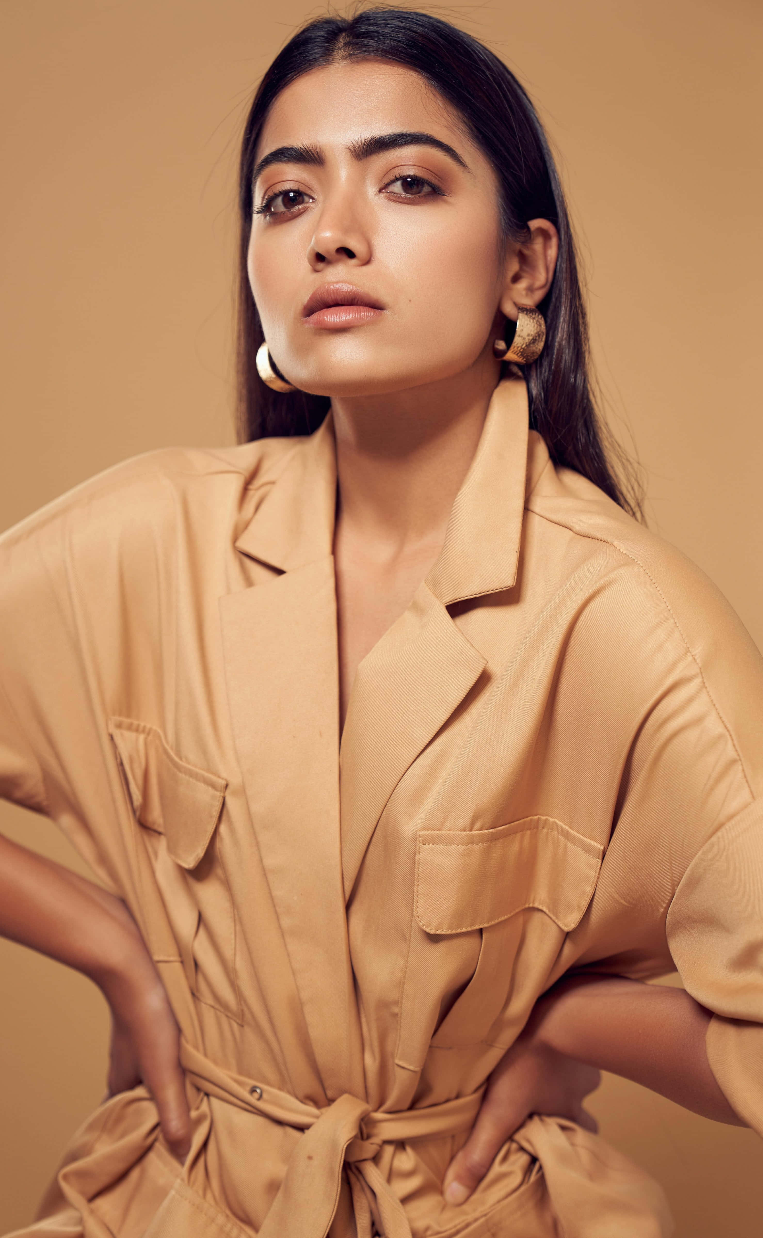 Rashmika Mandanna, tan satin jumpsuit, warm beige studio backdrop, 4K Phone Wallpaper