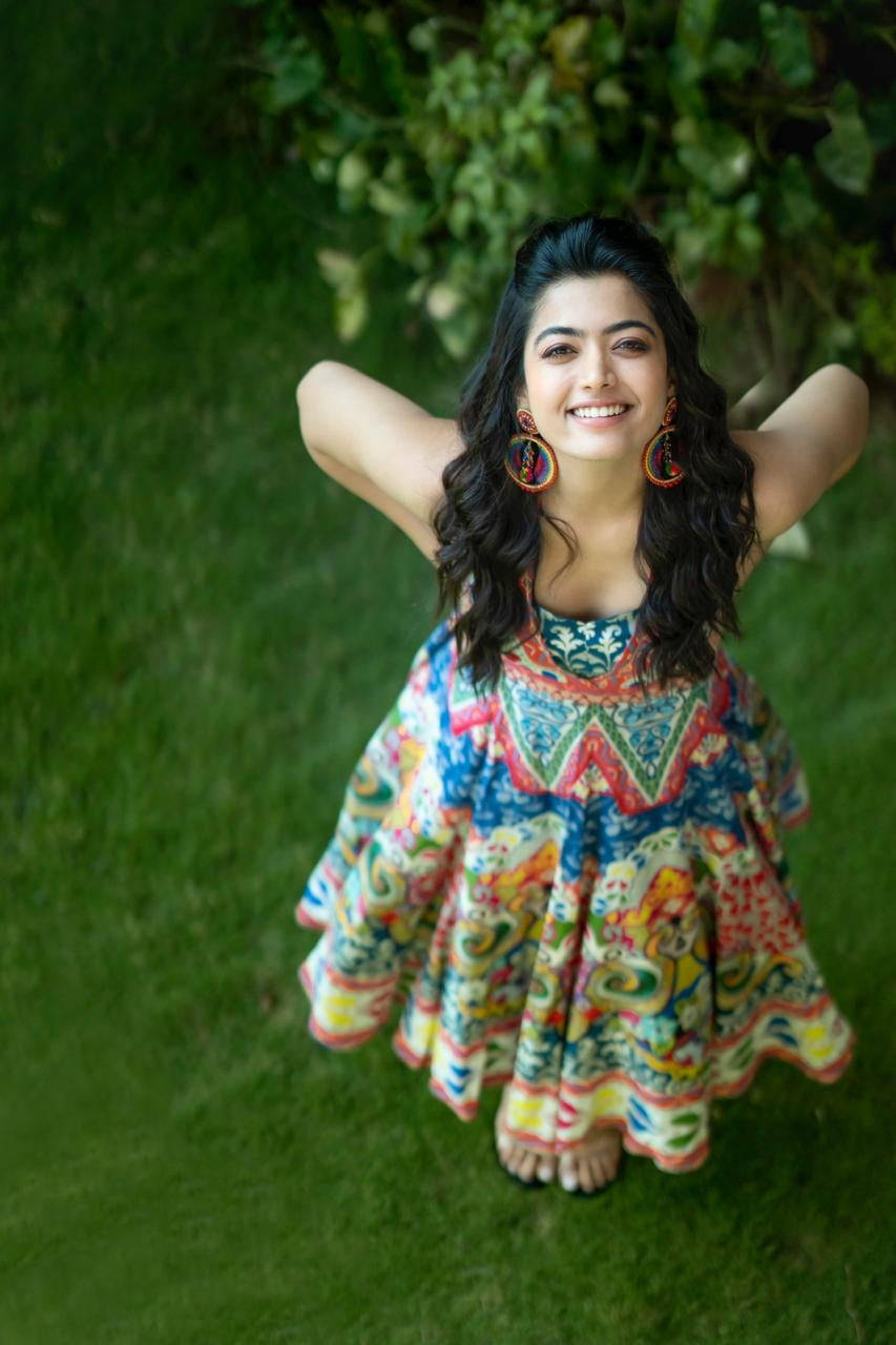 Rashmika Mandanna, colorful dress, lush green grass, HD Phone Wallpaper
