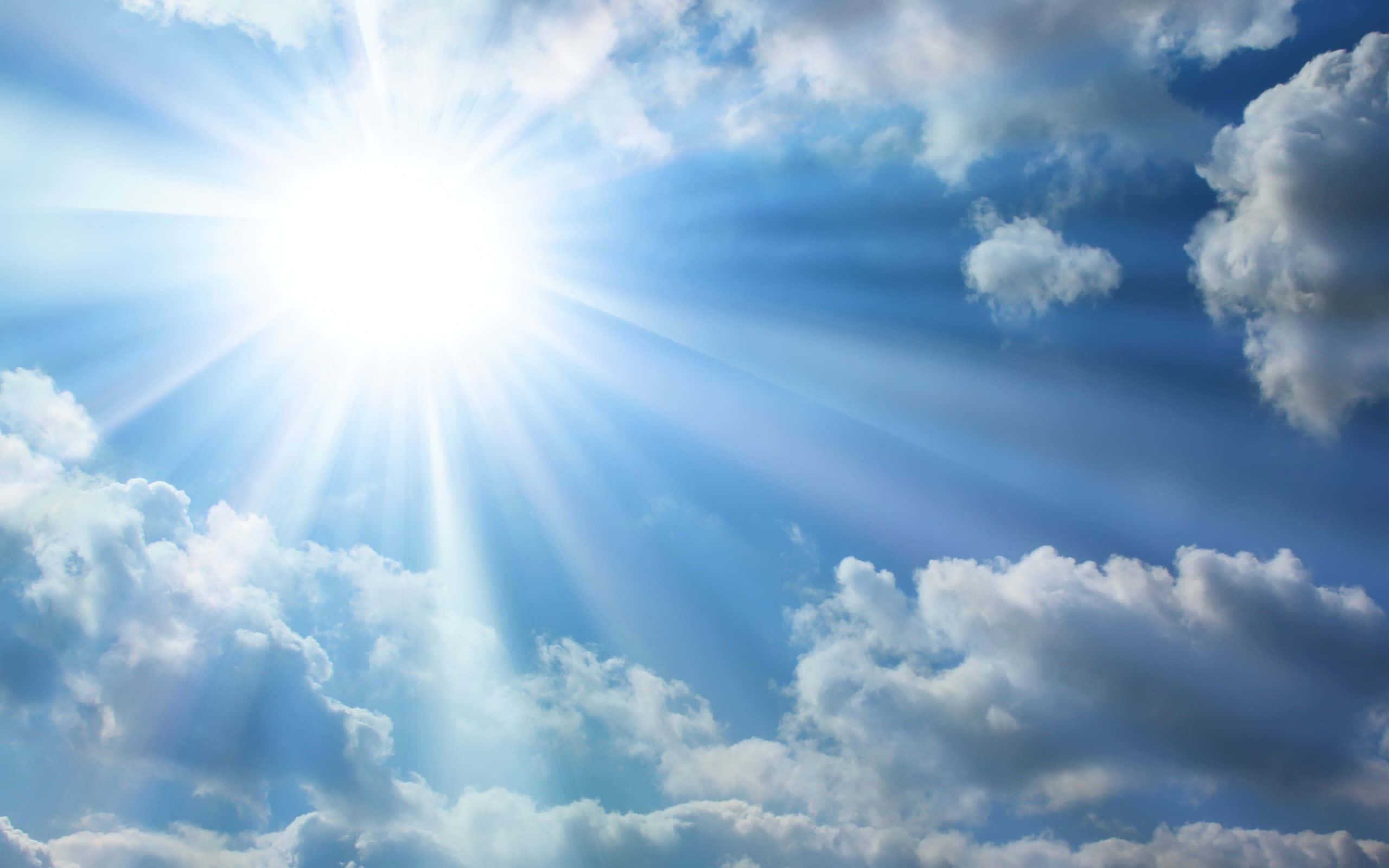 sunburst, fluffy white clouds, vibrant blue sky, 2K Desktop Wallpaper