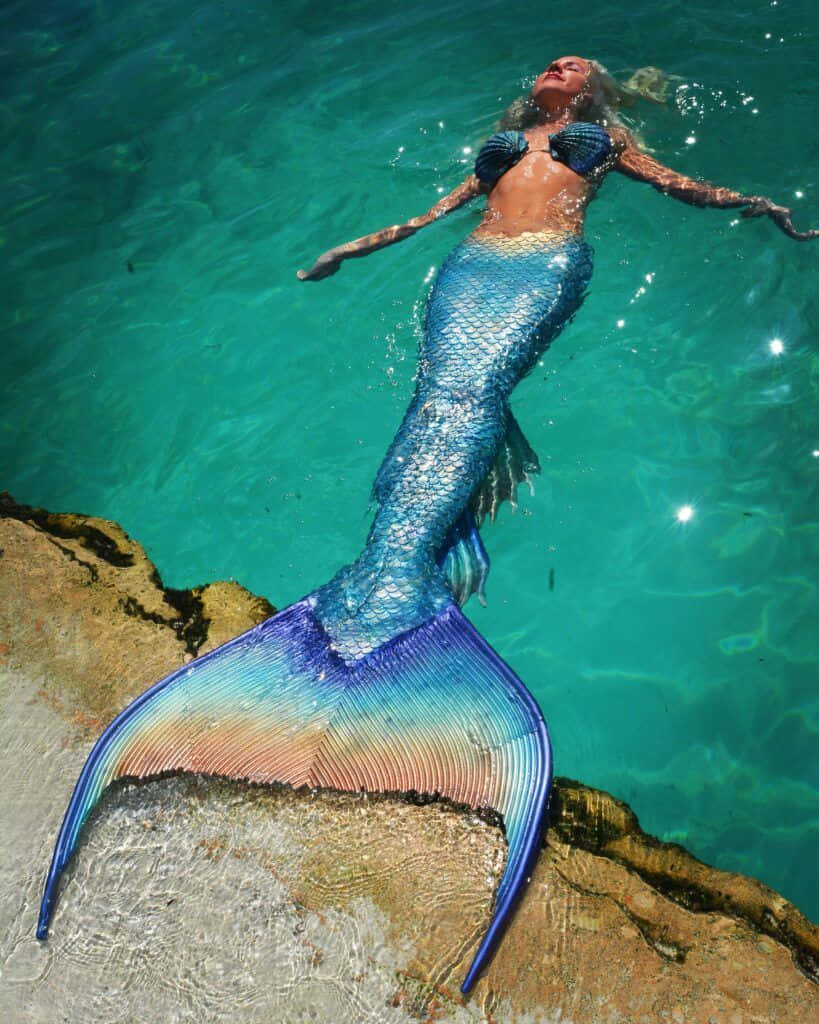 shimmering blue mermaid tail, clear turquoise water, sunlit rocks, SD Phone Wallpaper