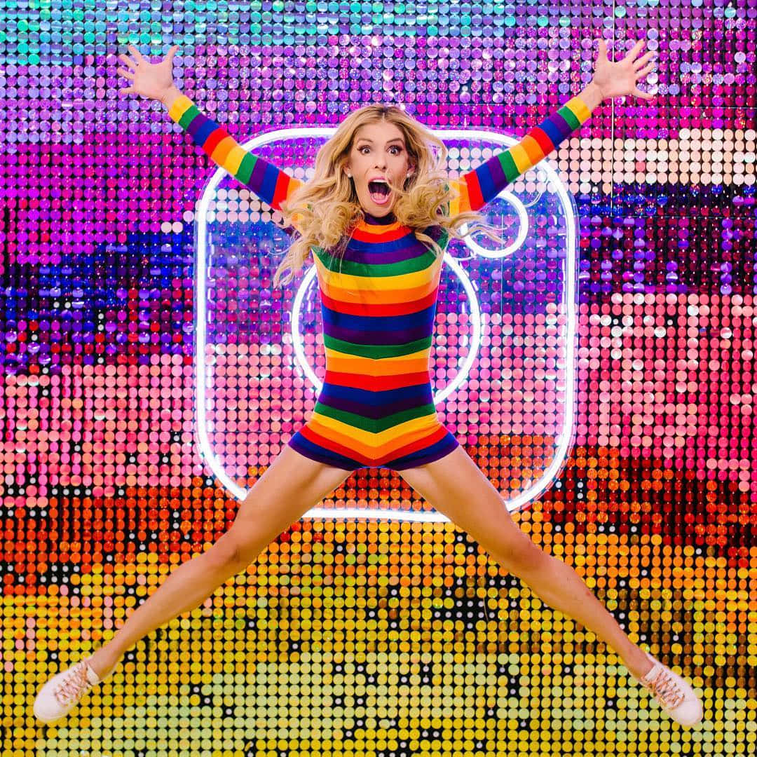 Rebecca Zamolo, rainbow striped outfit, glittering pixelated Instagram logo backdrop, SD Desktop Wallpaper