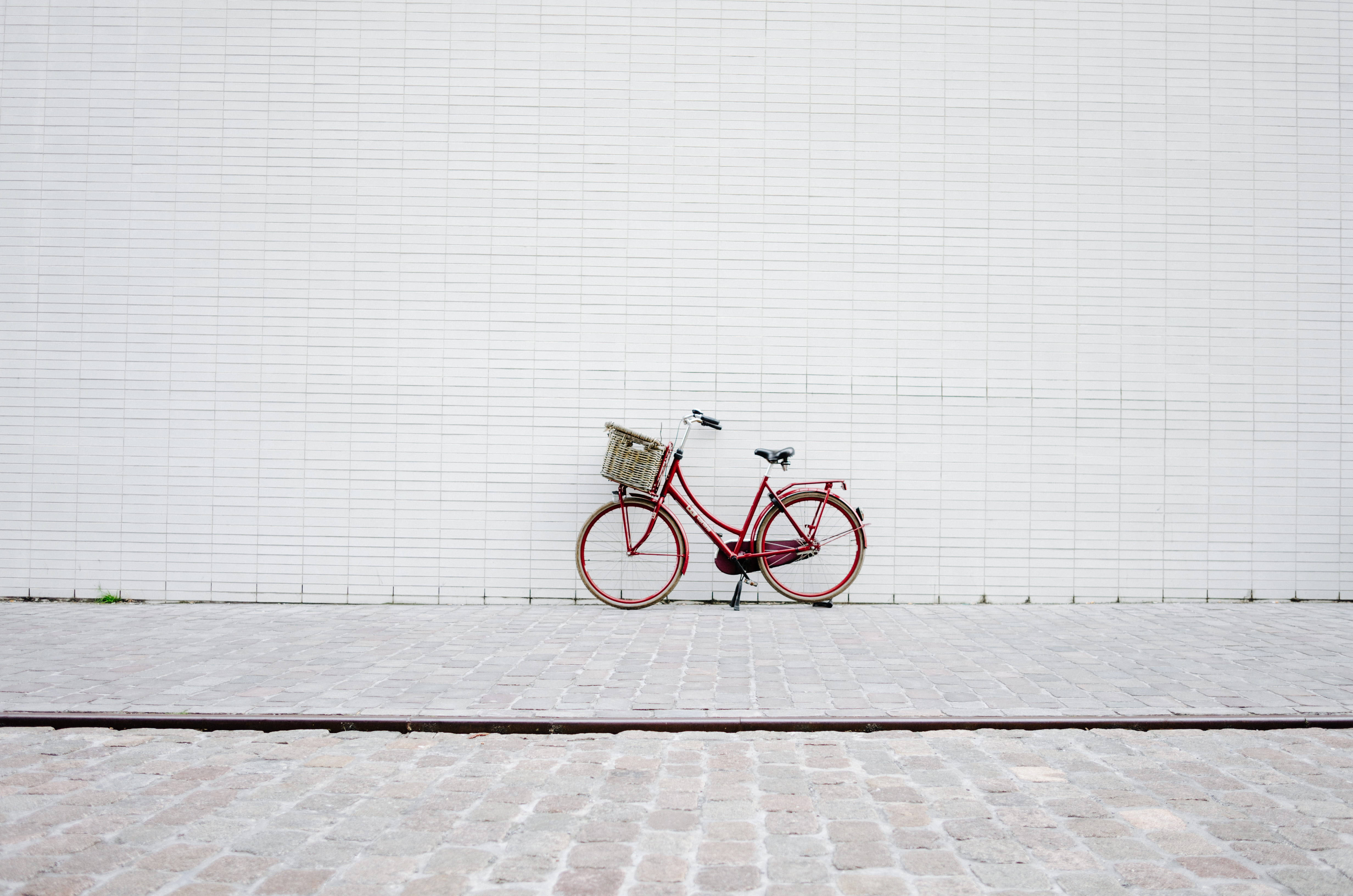 vintage red bicycle, wicker basket, stark white tiled wall, 4K Desktop Wallpaper
