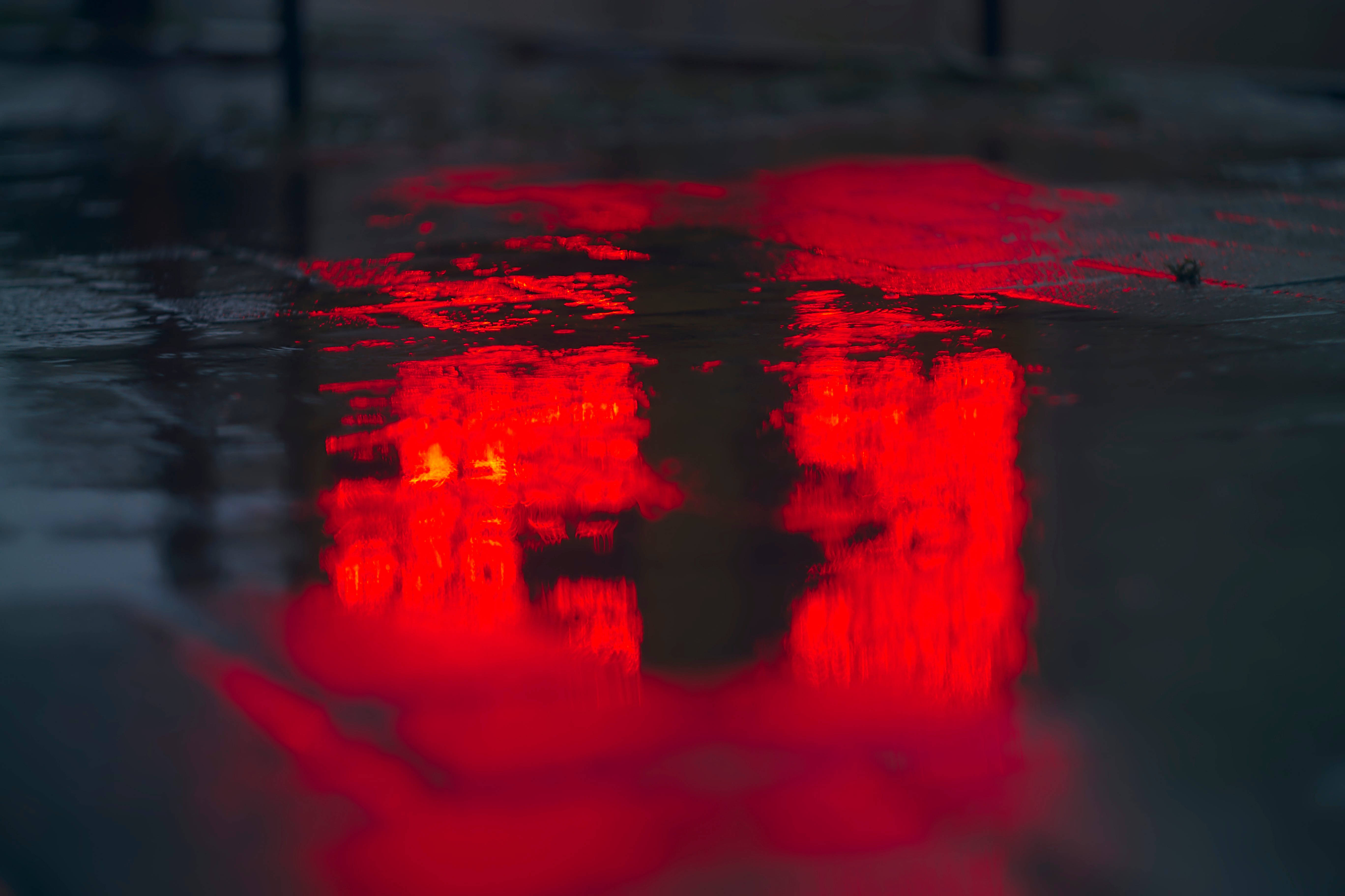 red car lights, rain-slicked urban pavement, moody nighttime glow, 5K Desktop Wallpaper
