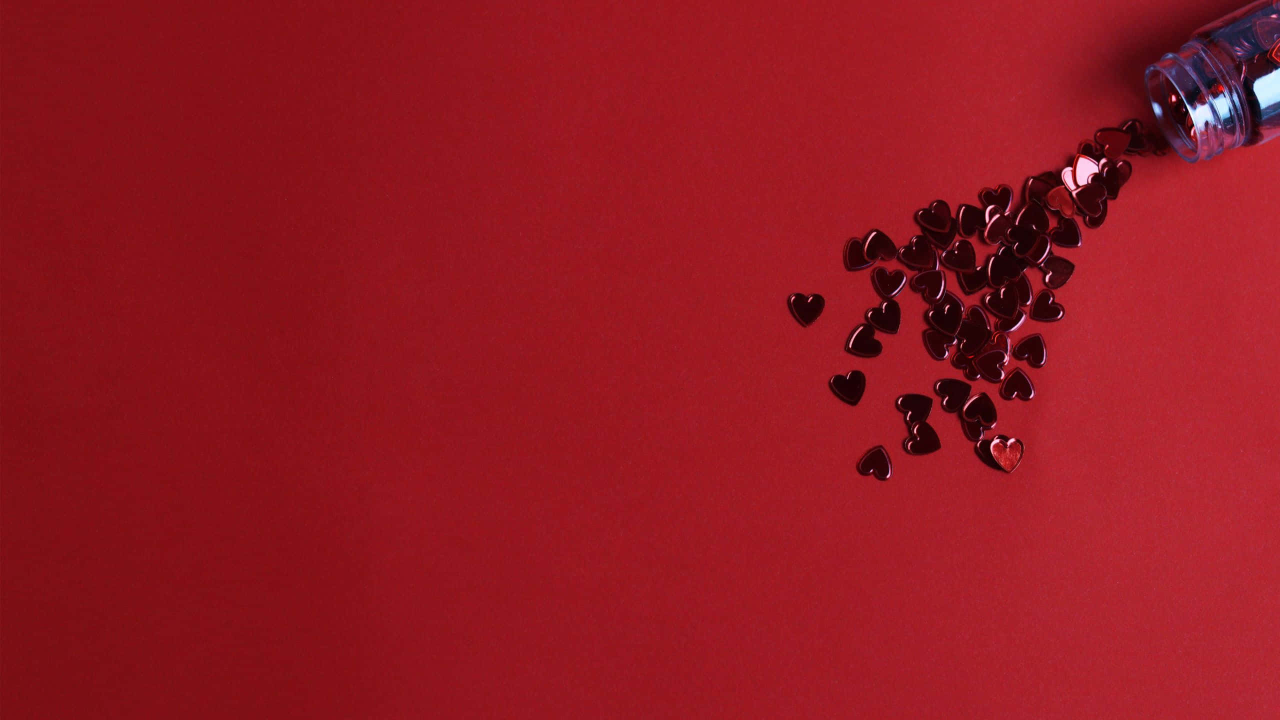 Red Pc, shiny red heart-shaped confetti, clear bottle, 2K Desktop Wallpaper
