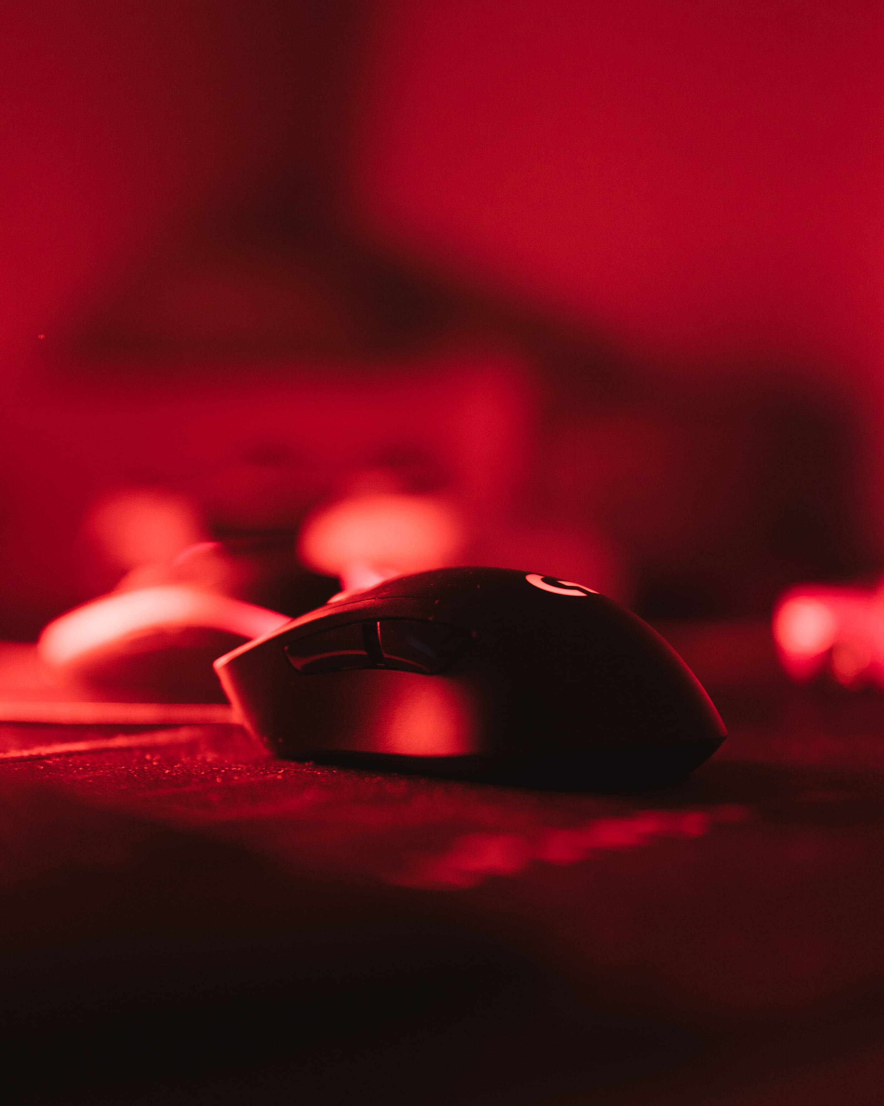 black gaming mouse, red ambient light, textured surface, 2K Phone Wallpaper