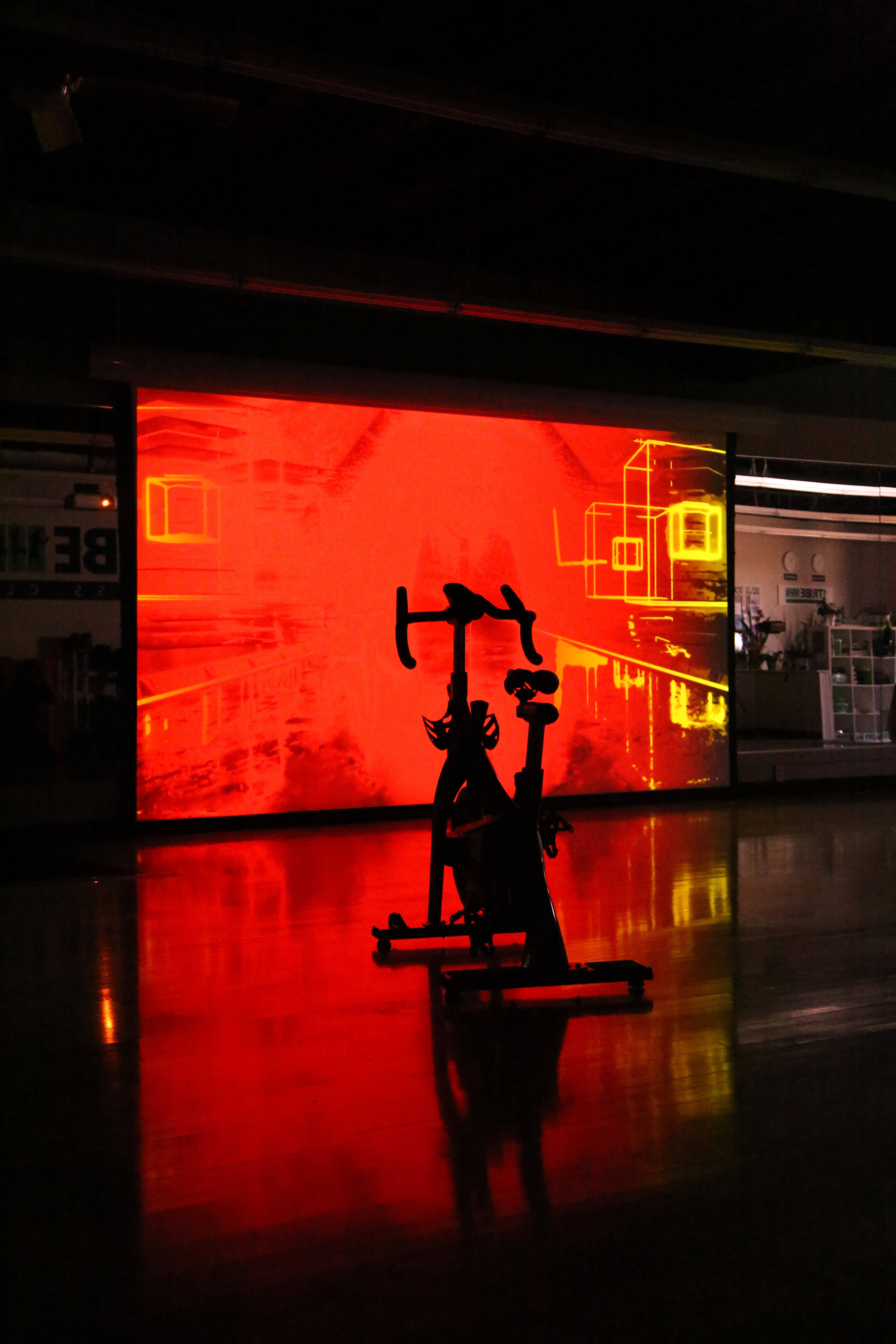 exercising red screen, stationary bike silhouette, glowing red digital screen, 5K Phone Wallpaper