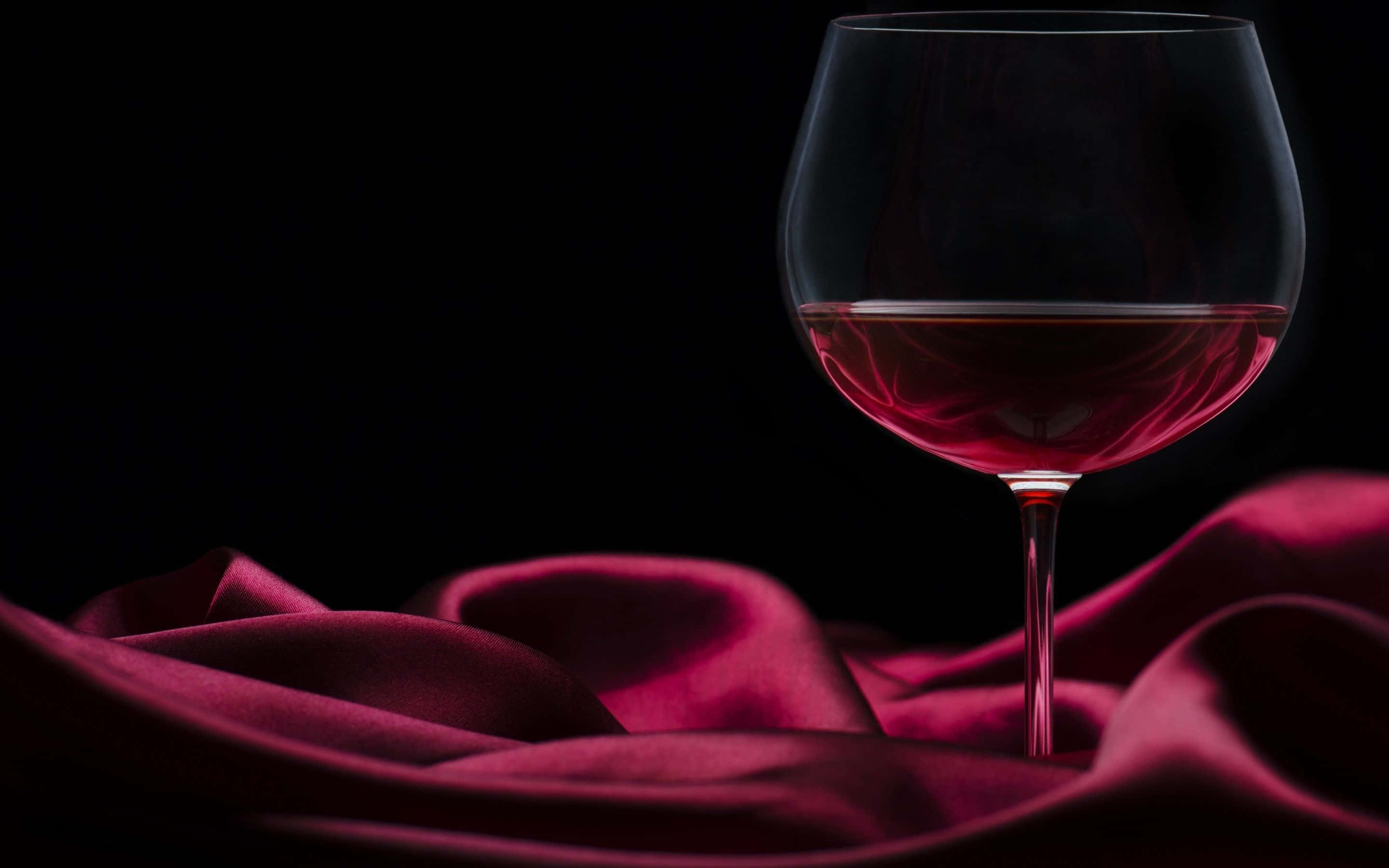 red wine glass, burgundy satin fabric, stark black background, 2K Desktop Wallpaper