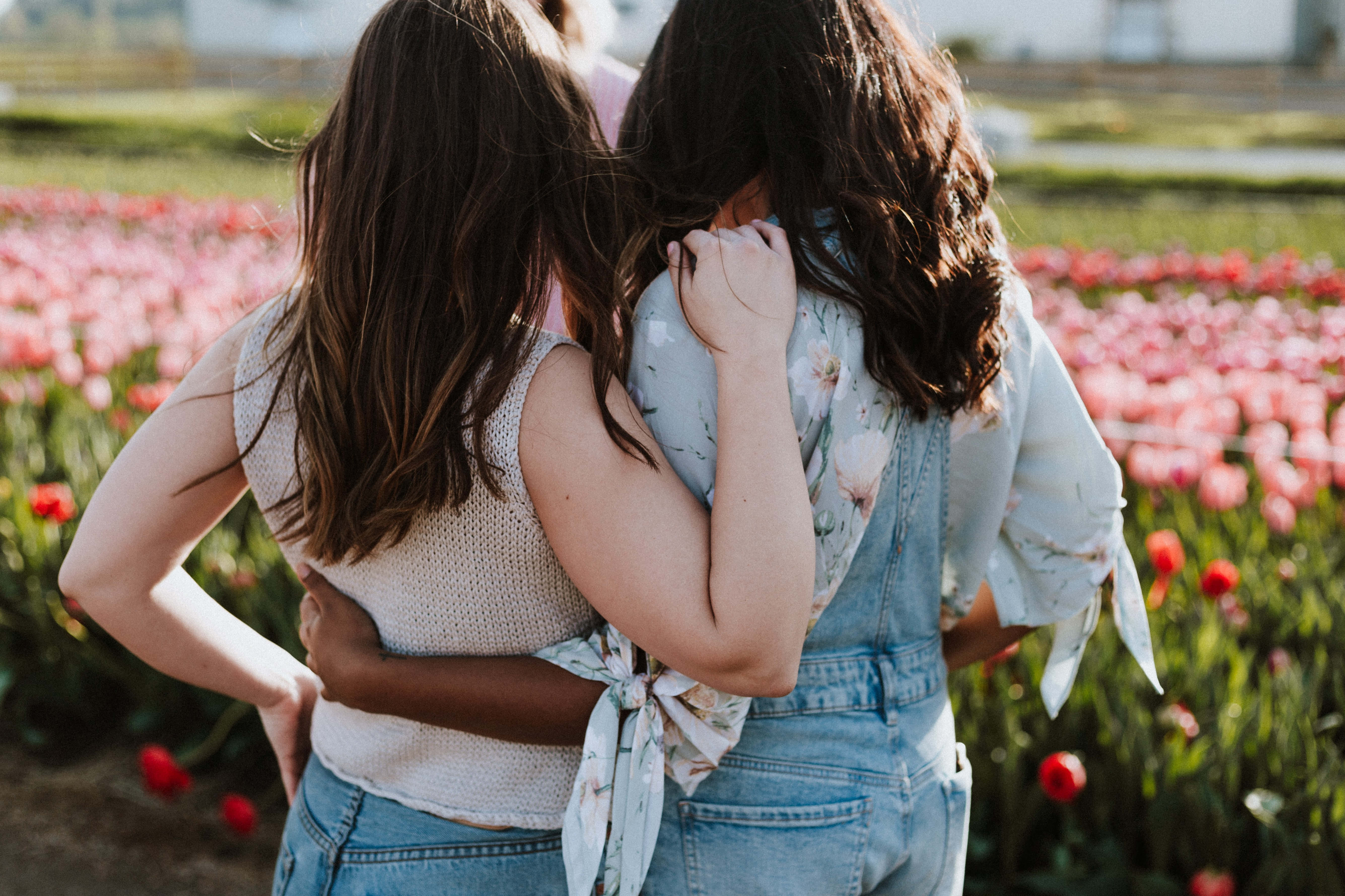 interracial relationship women, sunlit field, pink and red tulips, 5K Desktop Wallpaper