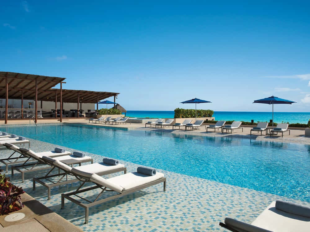 infinity pool, white lounge chairs, blue umbrellas, SD Desktop Wallpaper