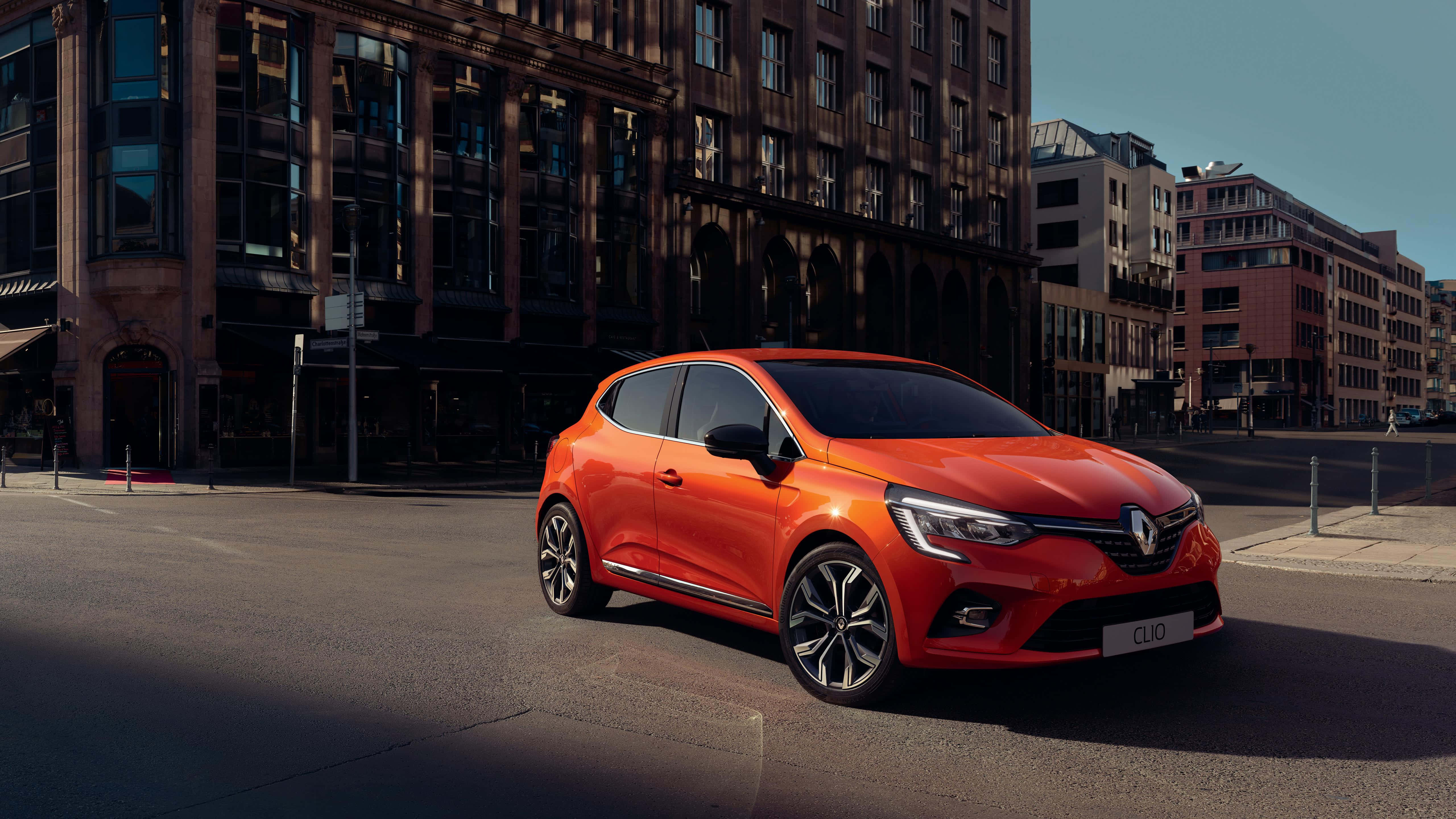 Renault Clio, vibrant orange, sunlit urban street, 5K Desktop Wallpaper