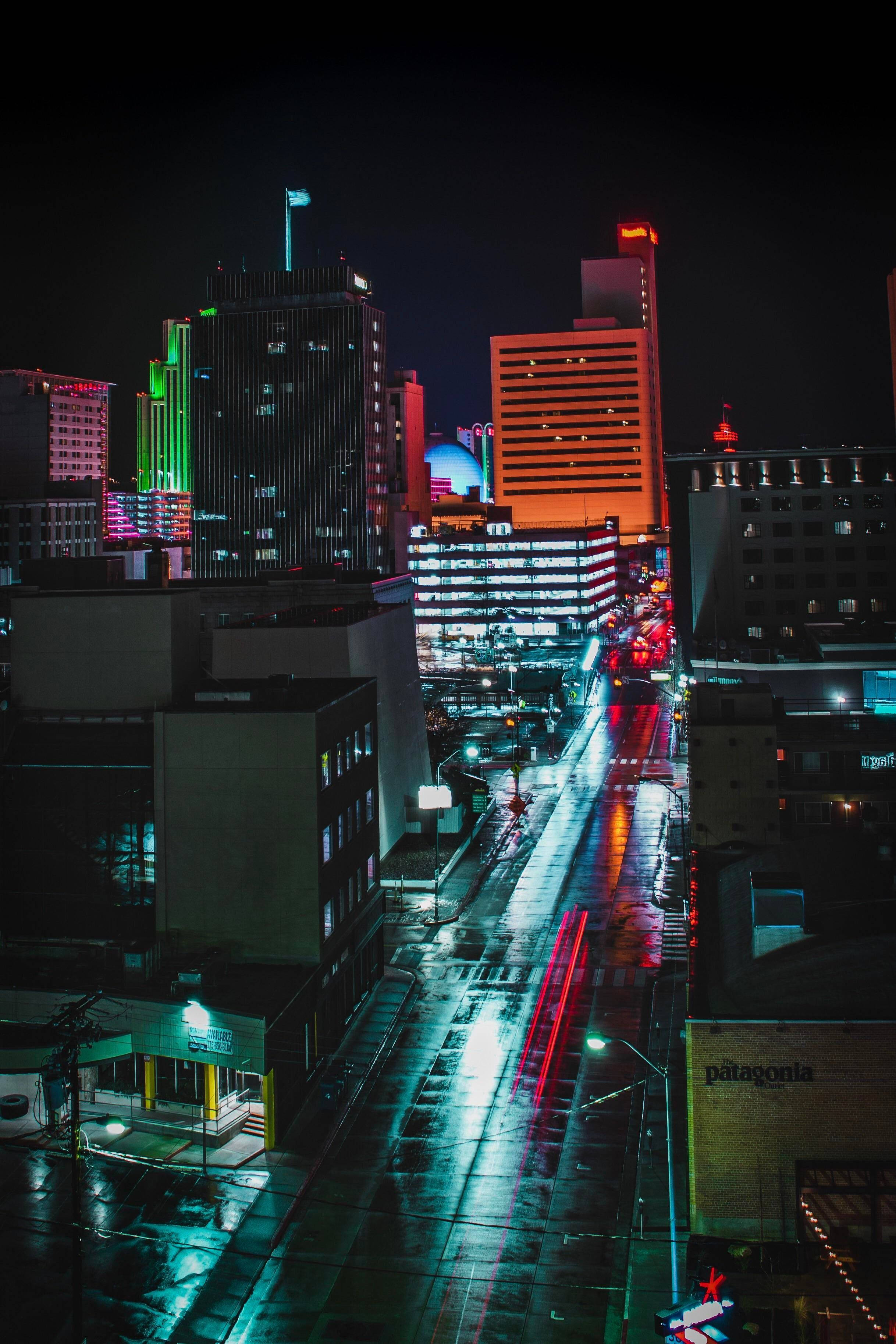 Reno, neon lights, rain-slicked city street, 2K Phone Wallpaper