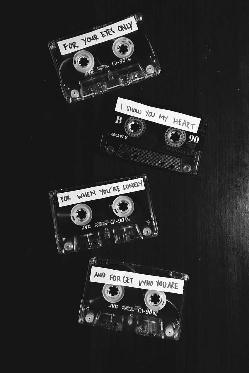 vintage cassette tapes, handwritten romantic messages, dark wooden surface, SD Phone Wallpaper