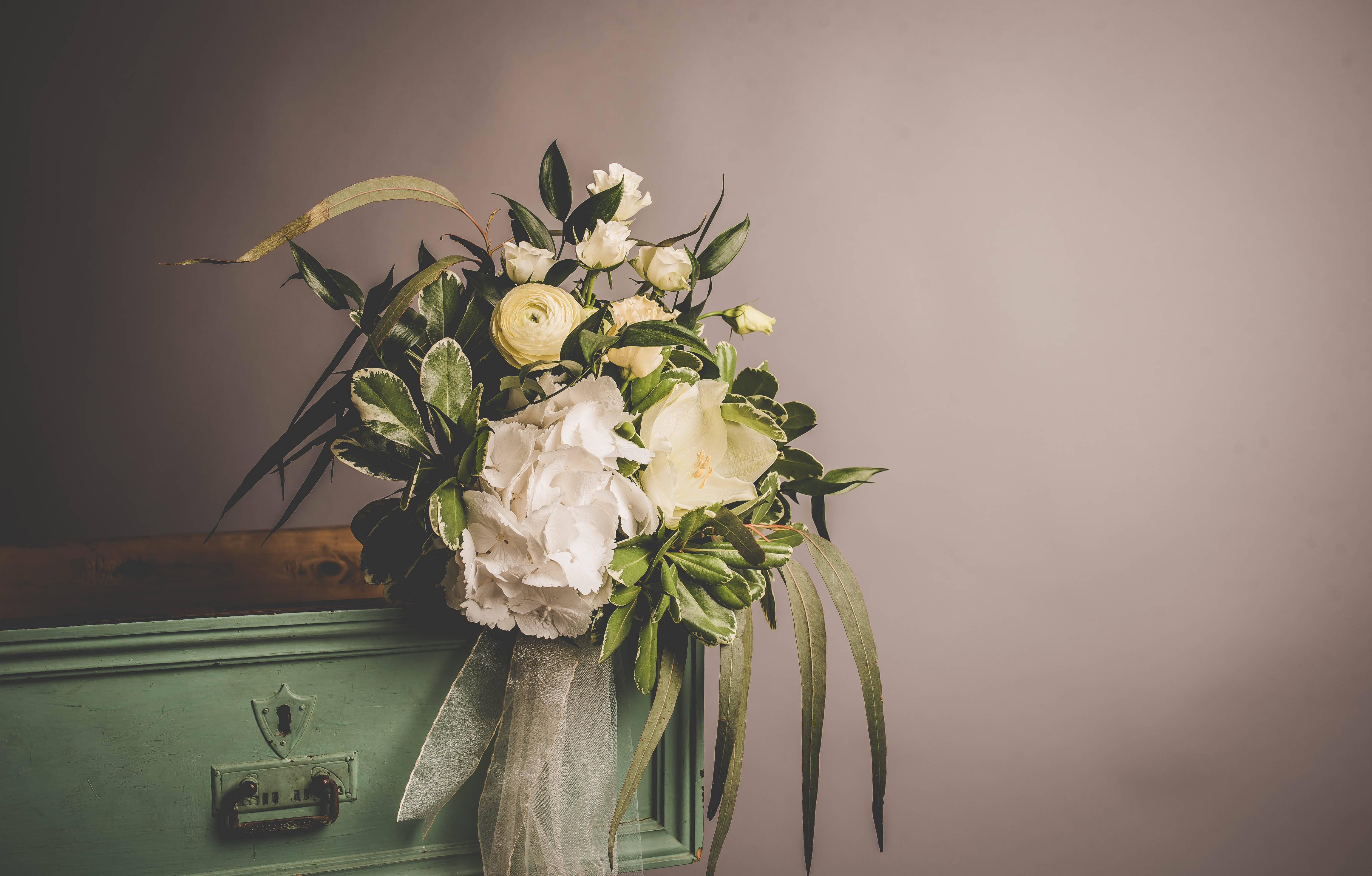 vintage green wooden chest, muted gray wall, white and cream flowers, 4K Desktop Wallpaper