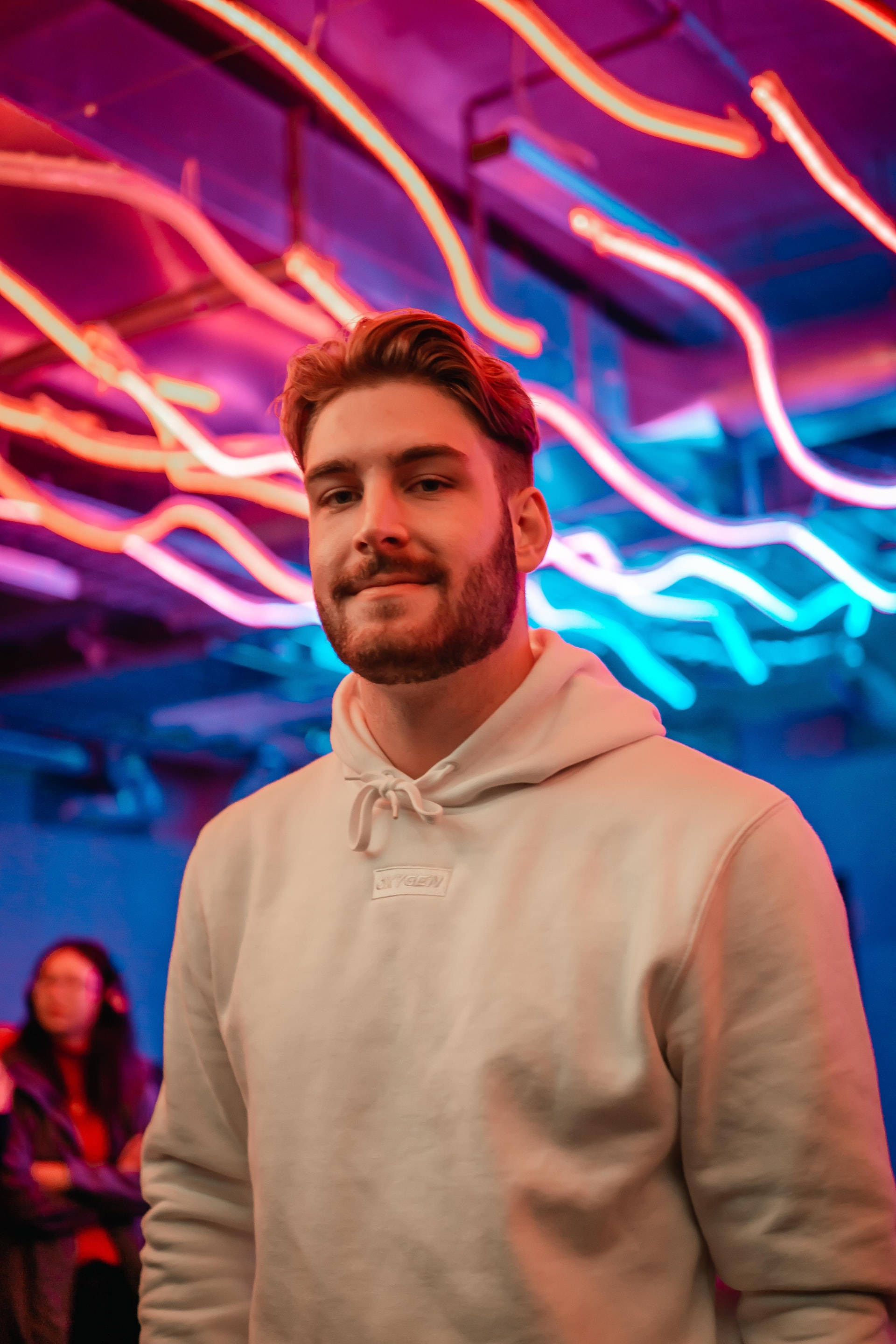 curly pompadour, white hoodie, vibrant pink and blue neon lights, 2K Phone Wallpaper