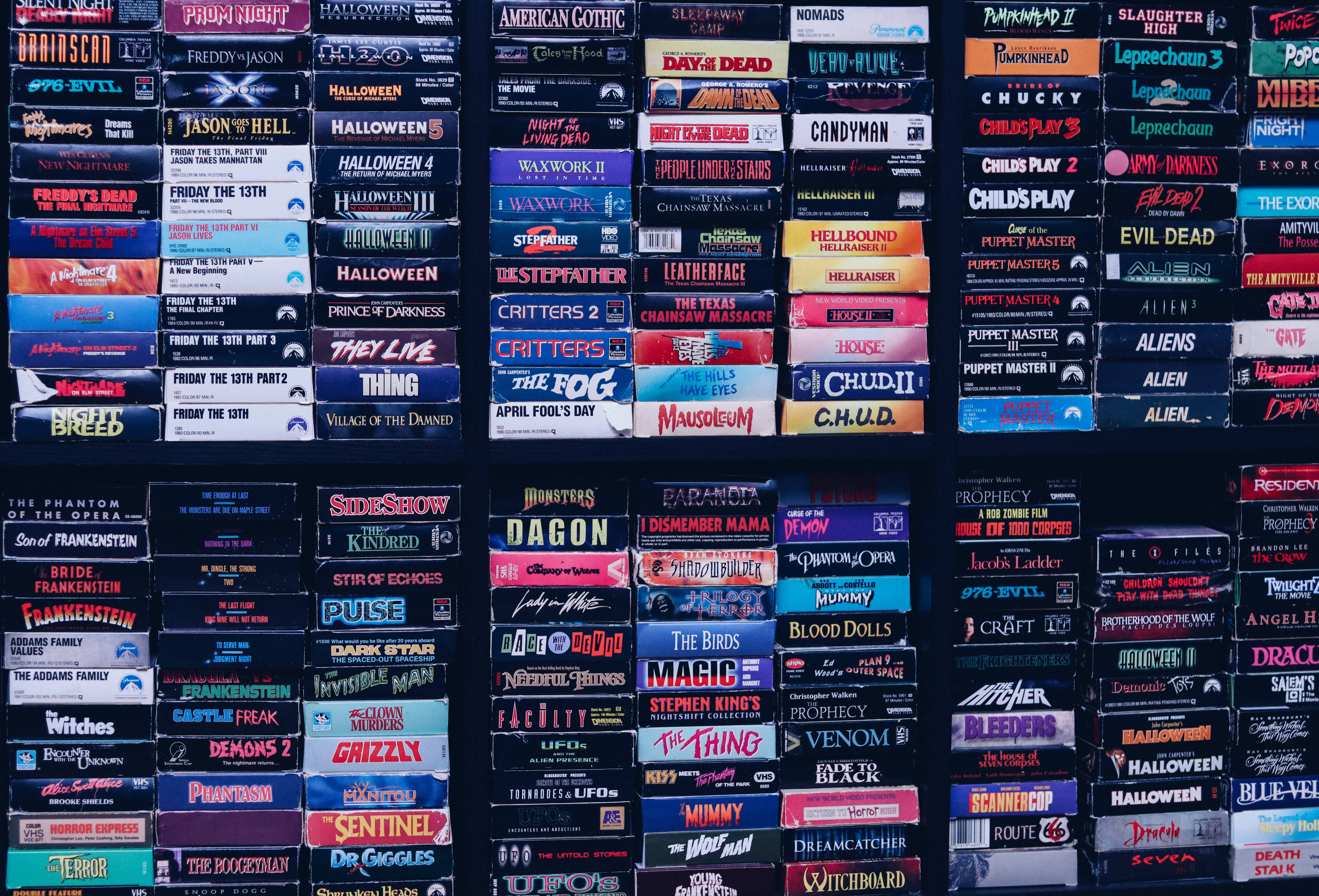 vintage VHS tapes, horror movie titles, bold colorful labels, 5K Desktop Wallpaper