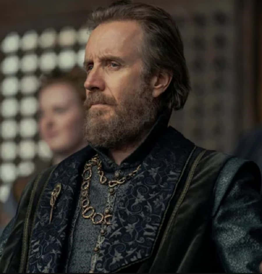 Rhys Ifans, dark blue and gold medieval attire, dimly lit castle interior, SD Phone Wallpaper