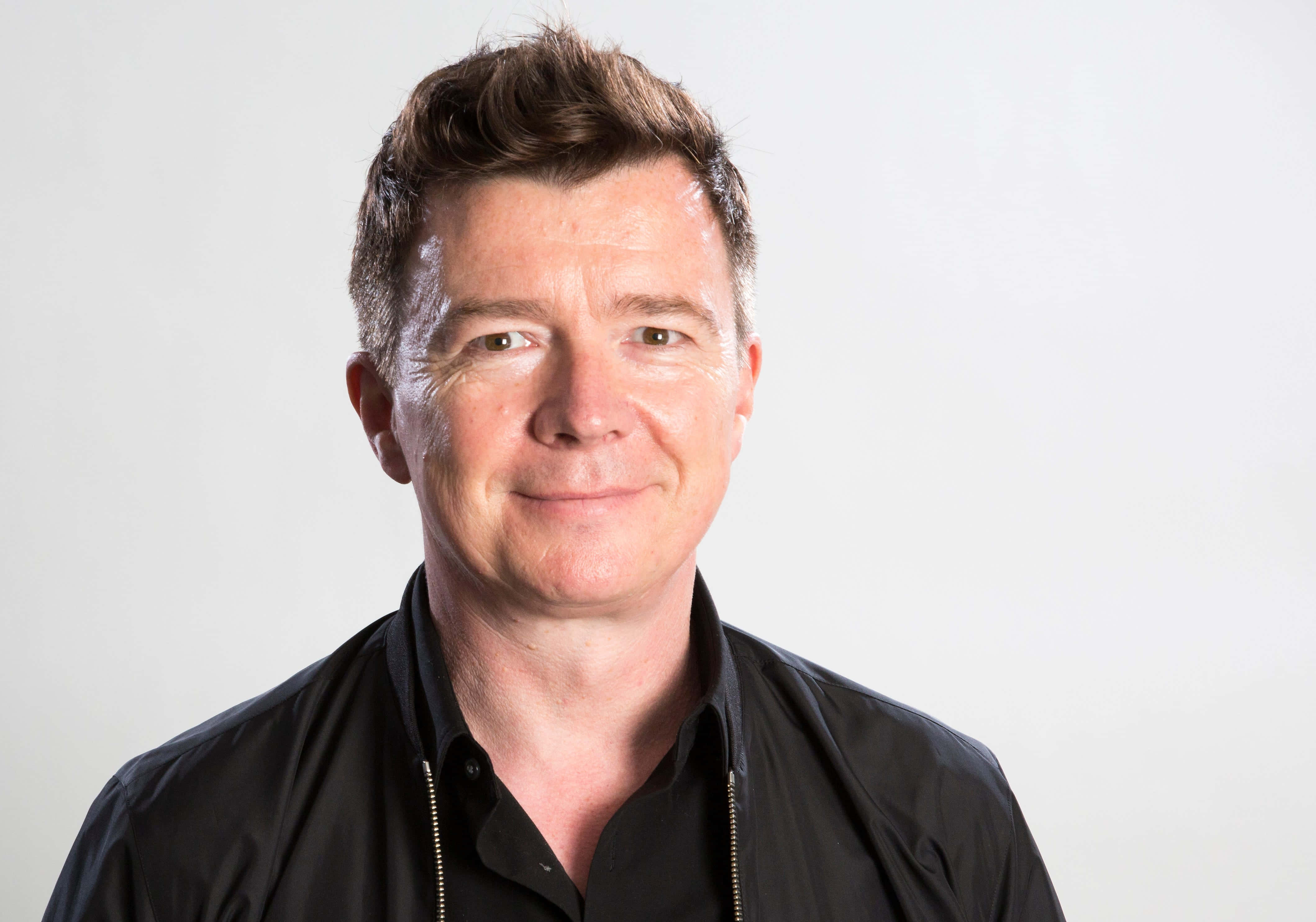 Rick Astley, black zippered jacket, short brown hair, 4K Desktop Wallpaper