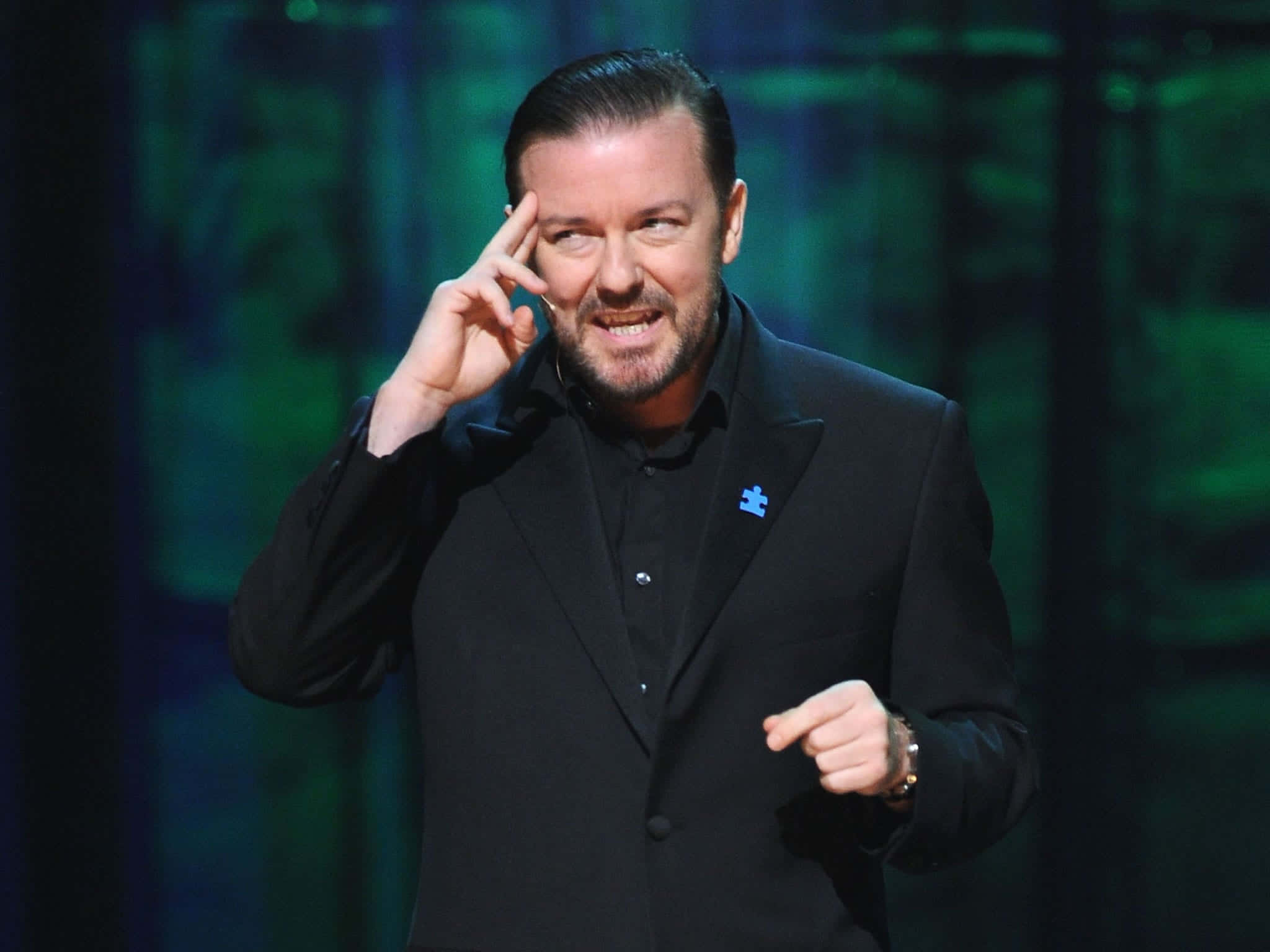 Ricky Gervais, black suit, dimly lit stage, Full HD Desktop Wallpaper