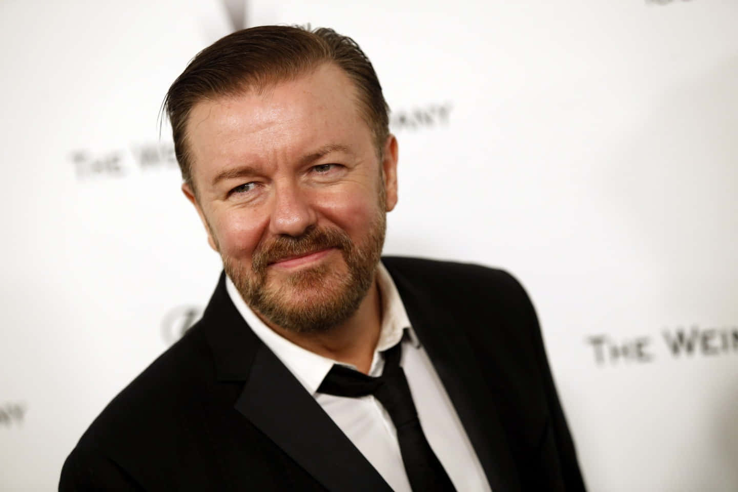 Ricky Gervais, black suit, white branded backdrop, HD Desktop Wallpaper