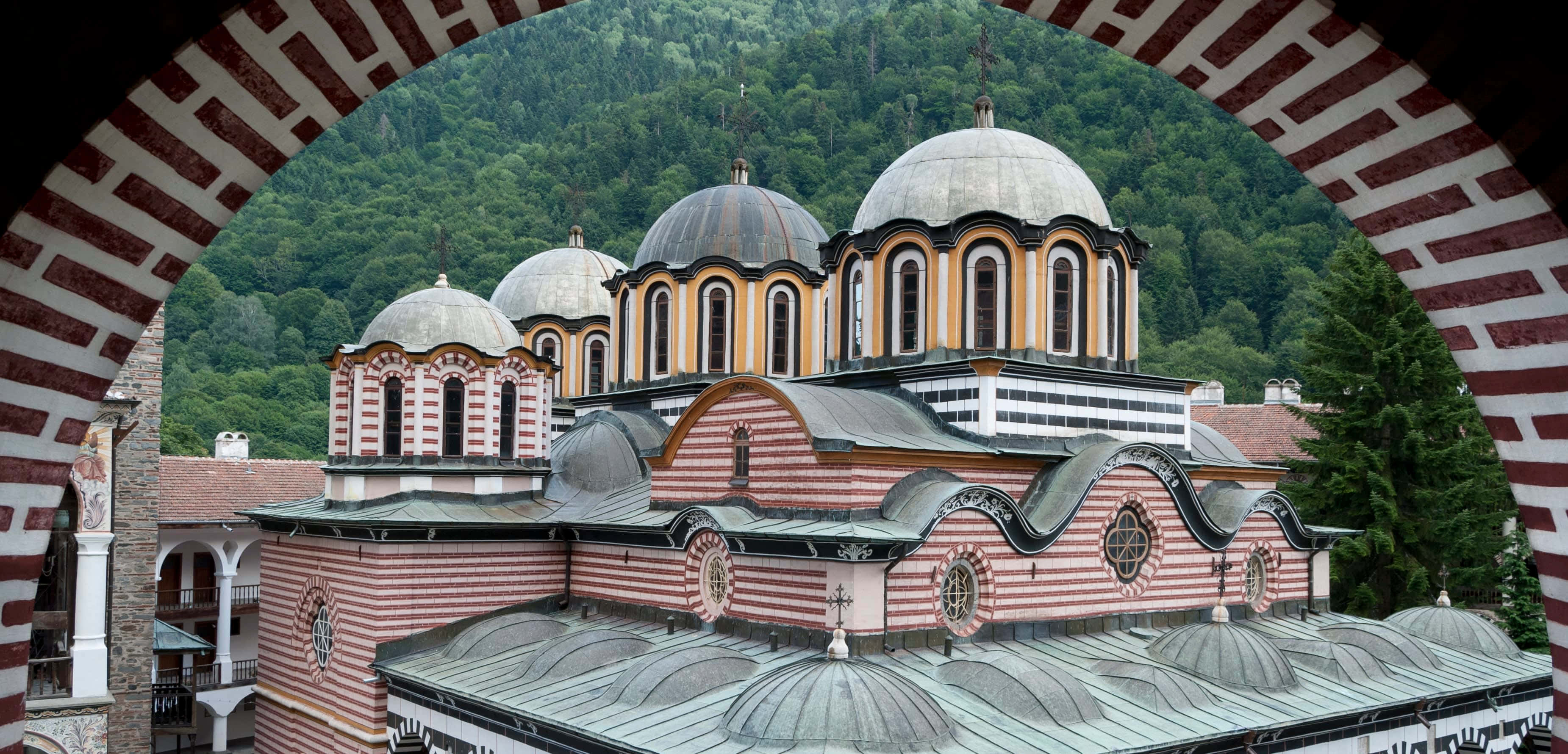 Rila Monastery, striped pink and white walls, domed roofs, 2K Desktop Wallpaper