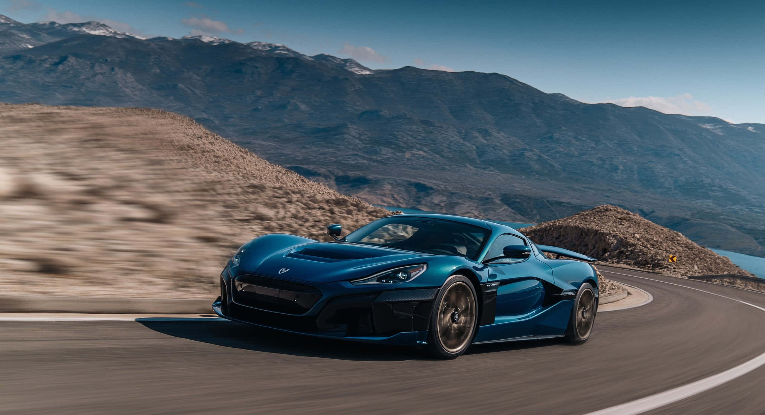 Rimac Nevera, sleek blue sports car, winding mountain road, 2K Desktop Wallpaper