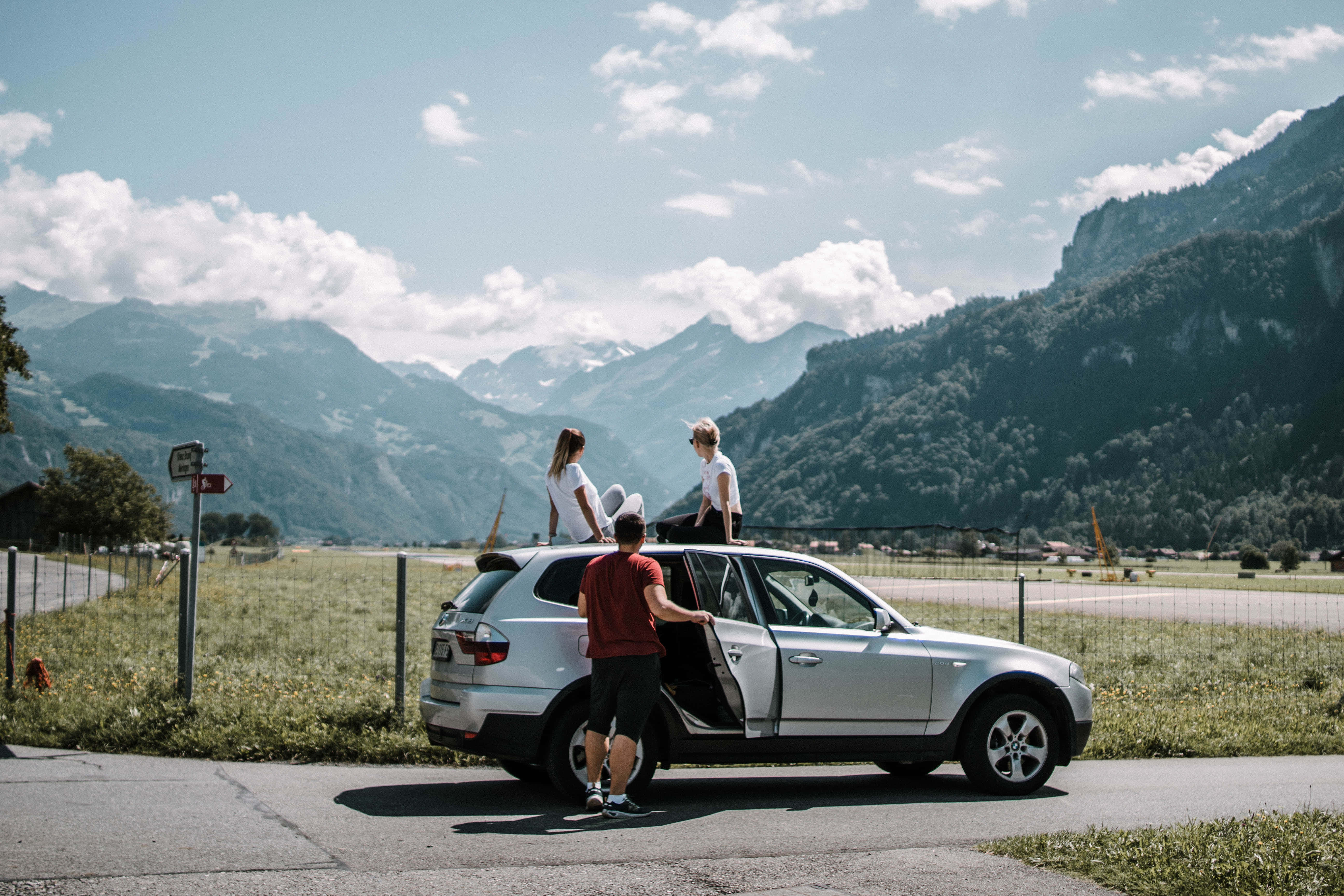 silver SUV, snow-capped mountains, lush green valleys, 5K Desktop Wallpaper