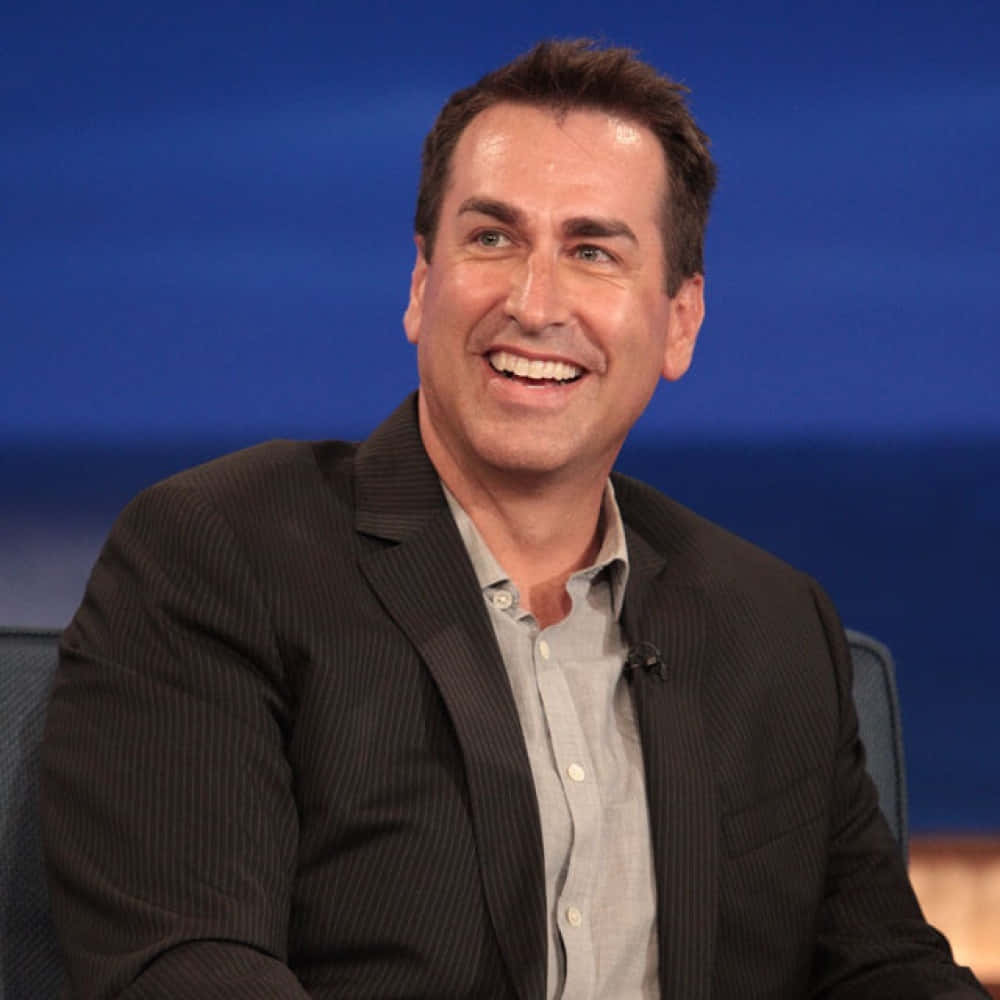 Rob Riggle, pinstripe suit, solid blue studio backdrop, SD Desktop Wallpaper