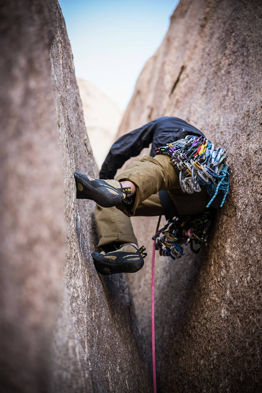 man climbing narrow rock, black jacket, tan pants, HD Phone Wallpaper
