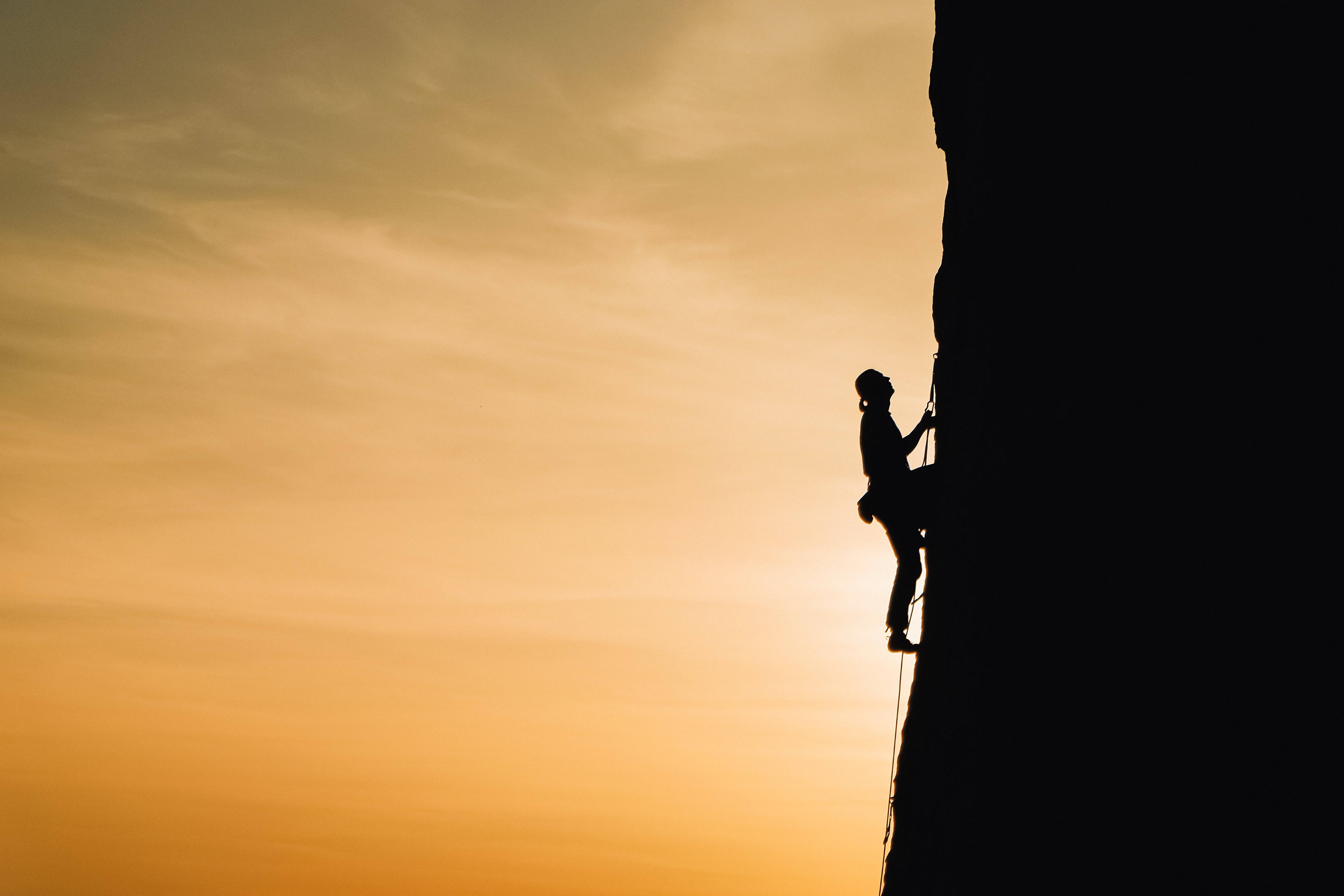 silhouetted man, rock climbing, sheer cliff face, 4K Desktop Wallpaper