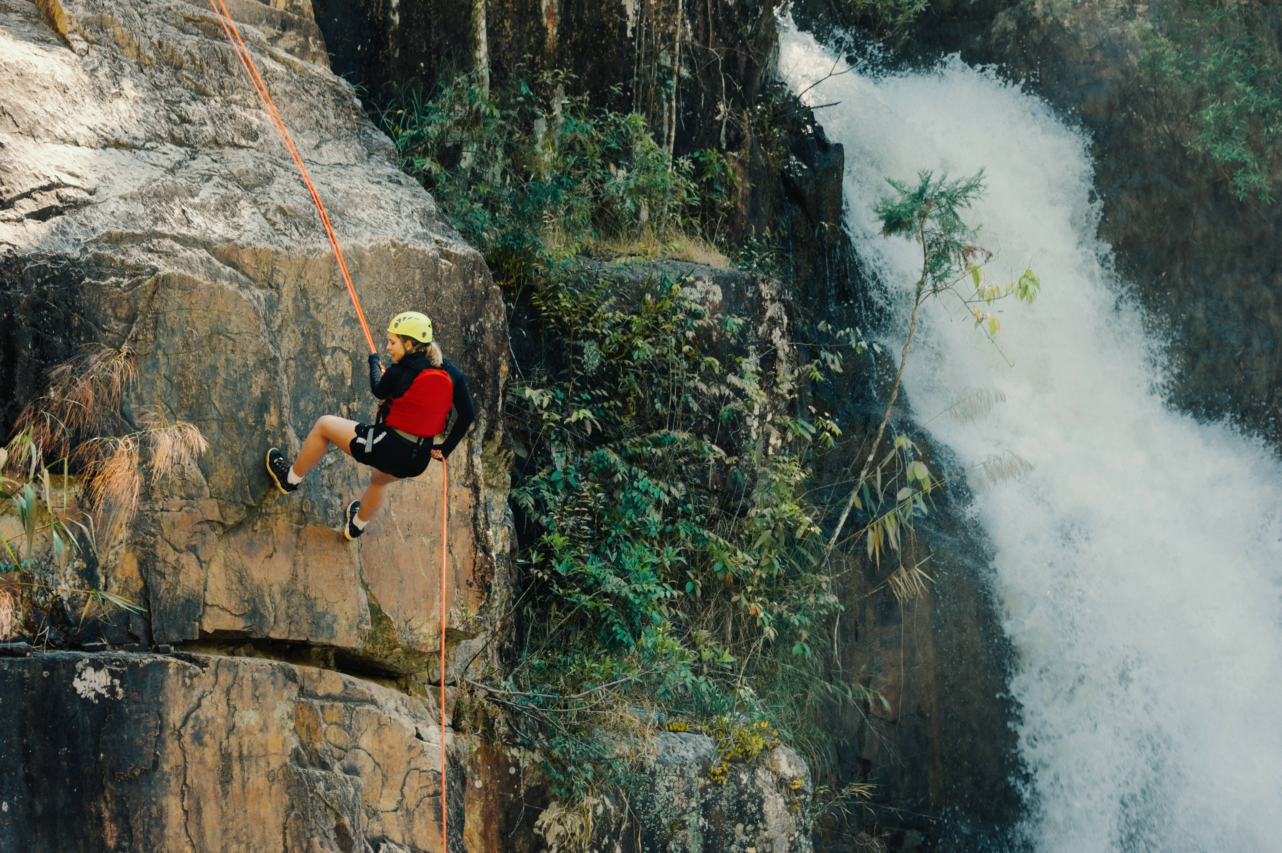 red gear, rugged cliff, roaring waterfall, 4K Desktop Wallpaper