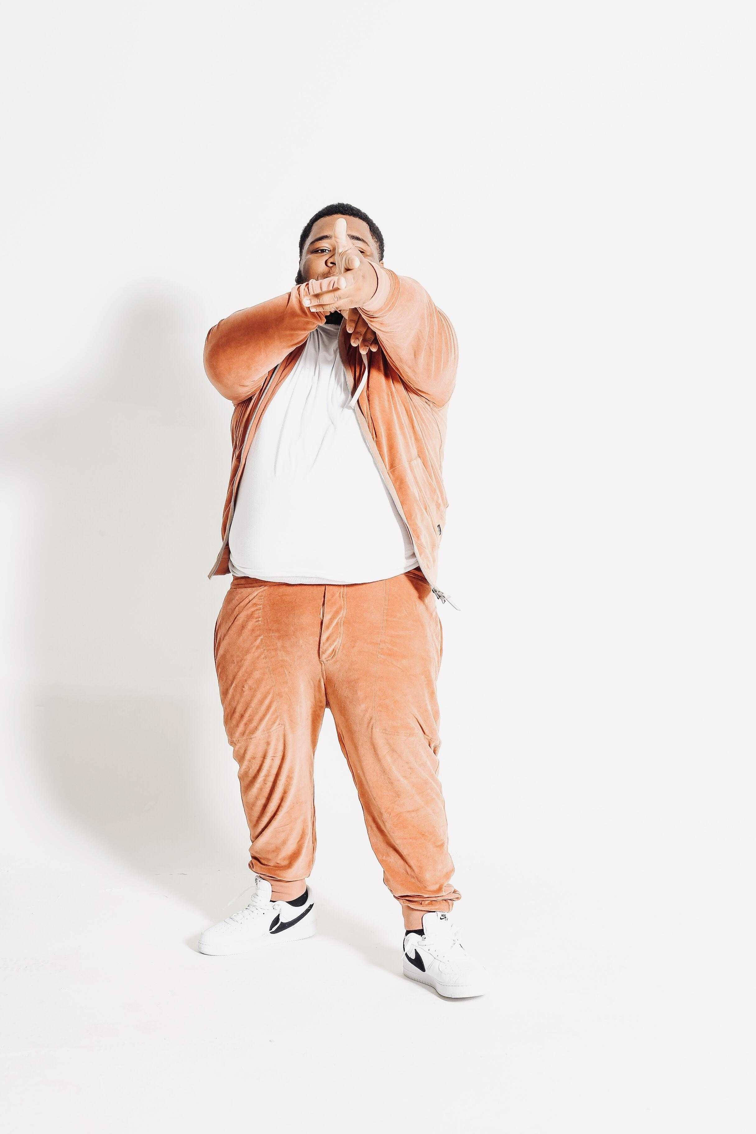 Rod Wave, rust-colored velour tracksuit, white studio background, 2K Phone Wallpaper