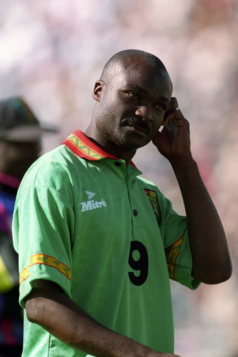 Roger Milla, green number nine jersey, sunlit pitch, SD Phone Wallpaper
