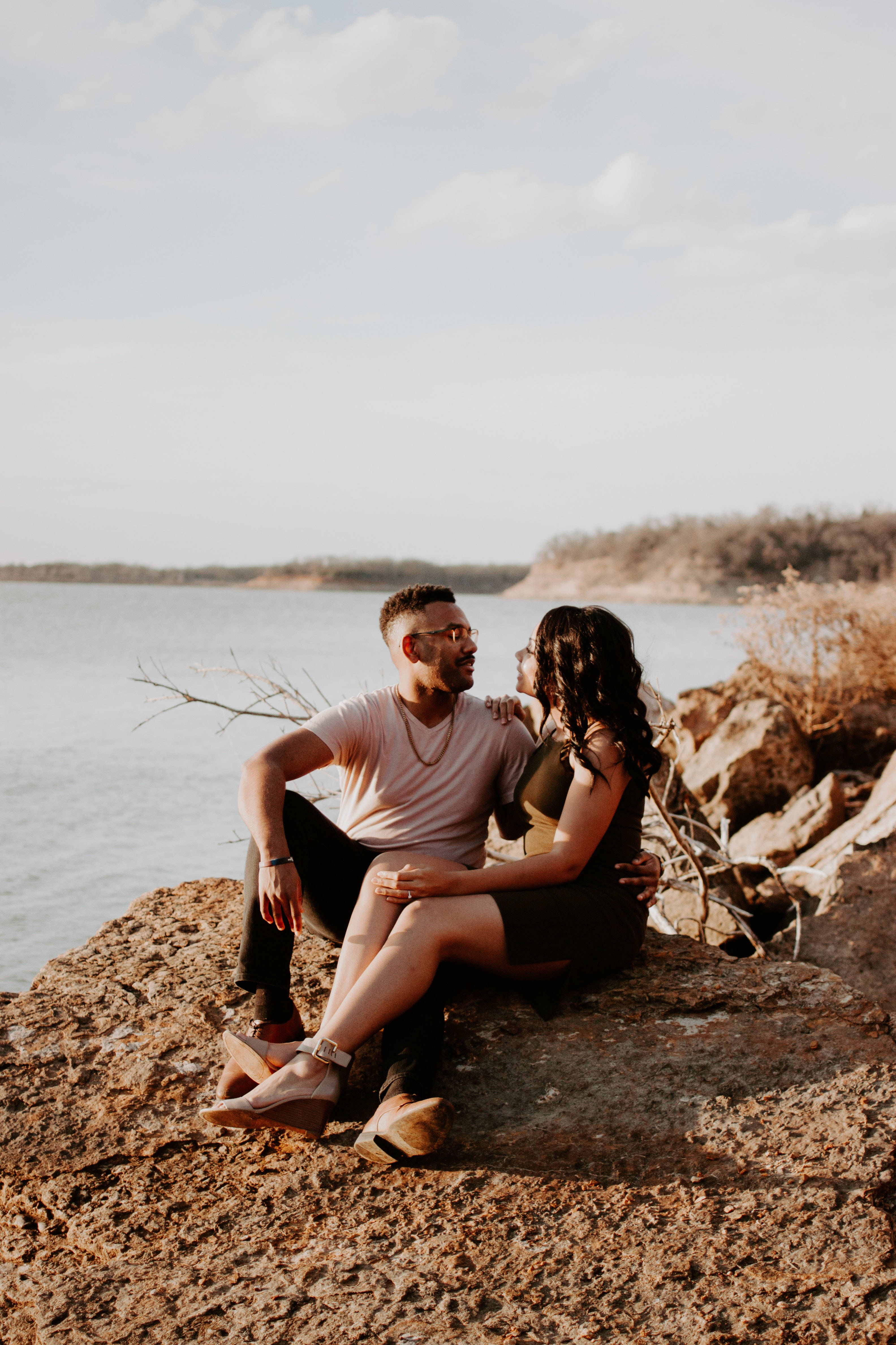 romantic couple, sunlit rocky shore, calm water, 4K Phone Wallpaper