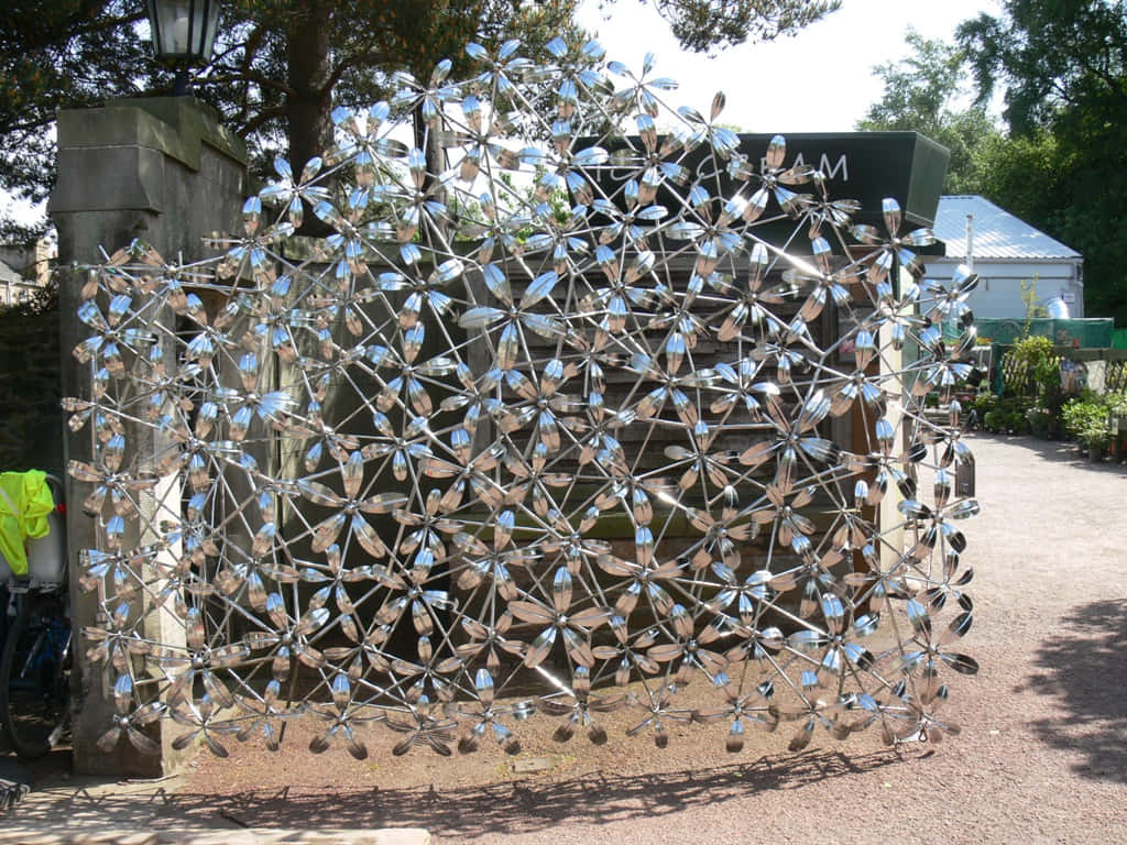 reflective metallic flower sculpture, spoon blades, sunny garden backdrop, SD Desktop Wallpaper