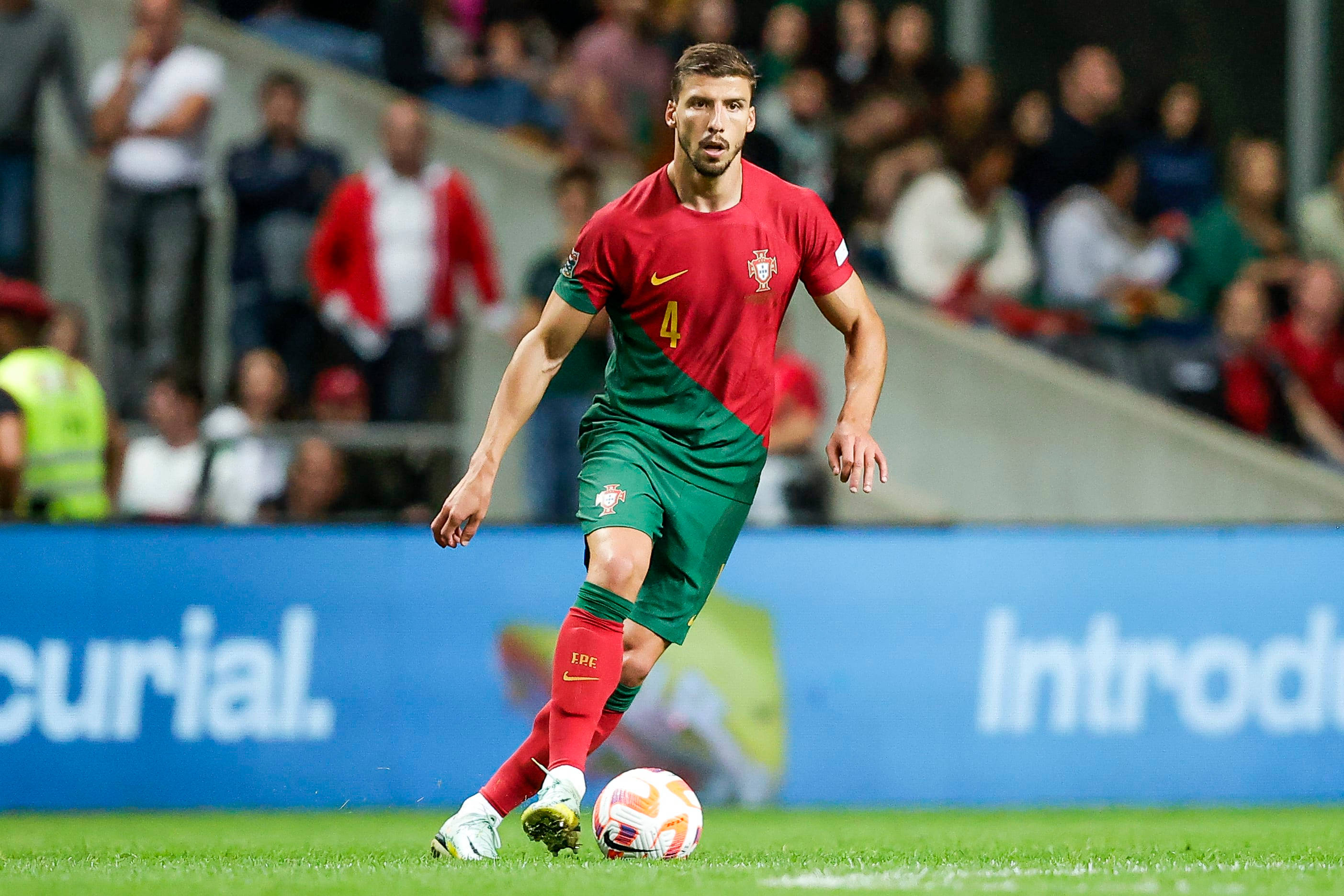 Ruben Dias, red and green uniform, stadium field, 2K Desktop Wallpaper