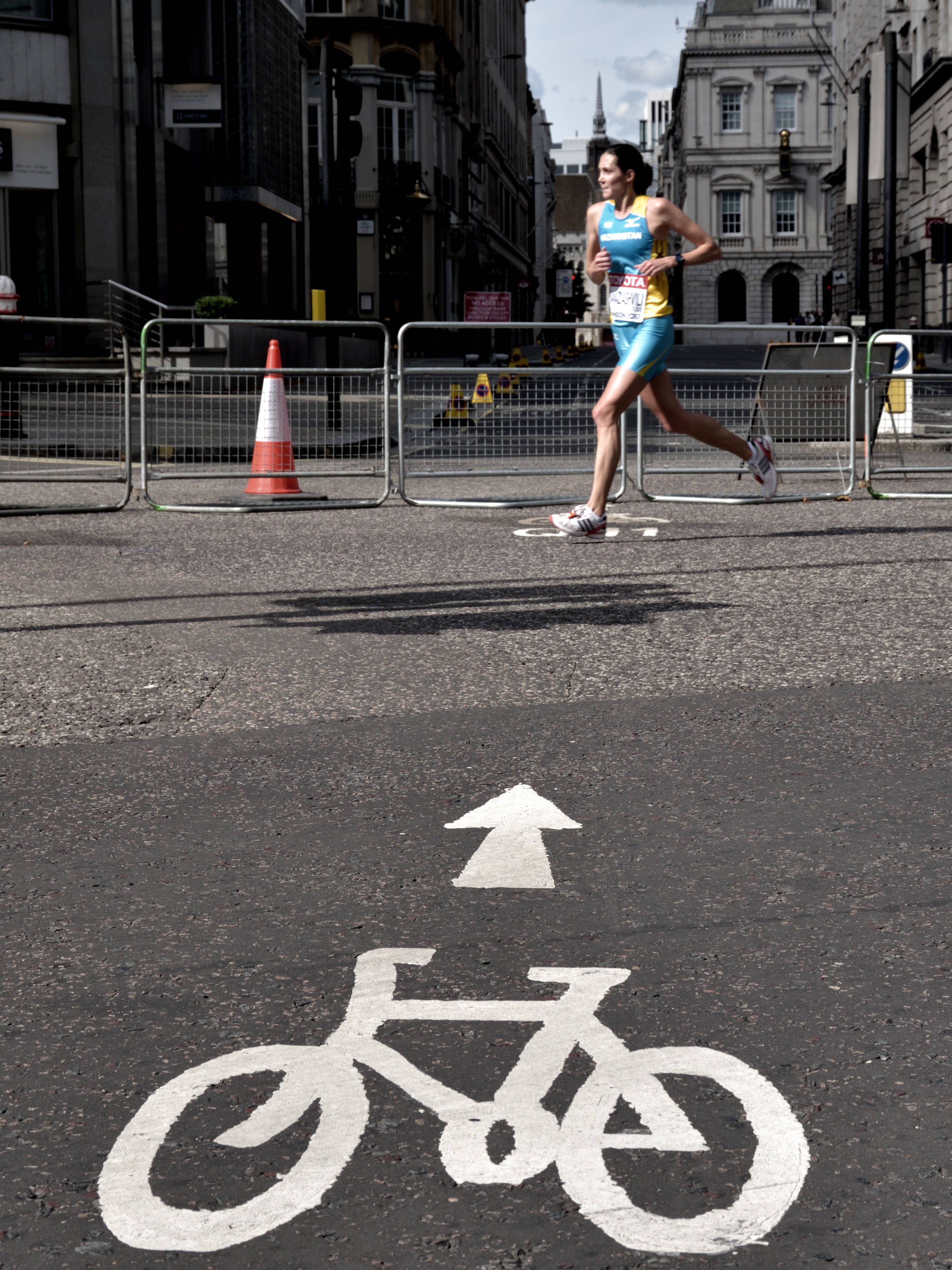 female runner, blue and yellow athletic gear, grey concrete road, 2K Phone Wallpaper