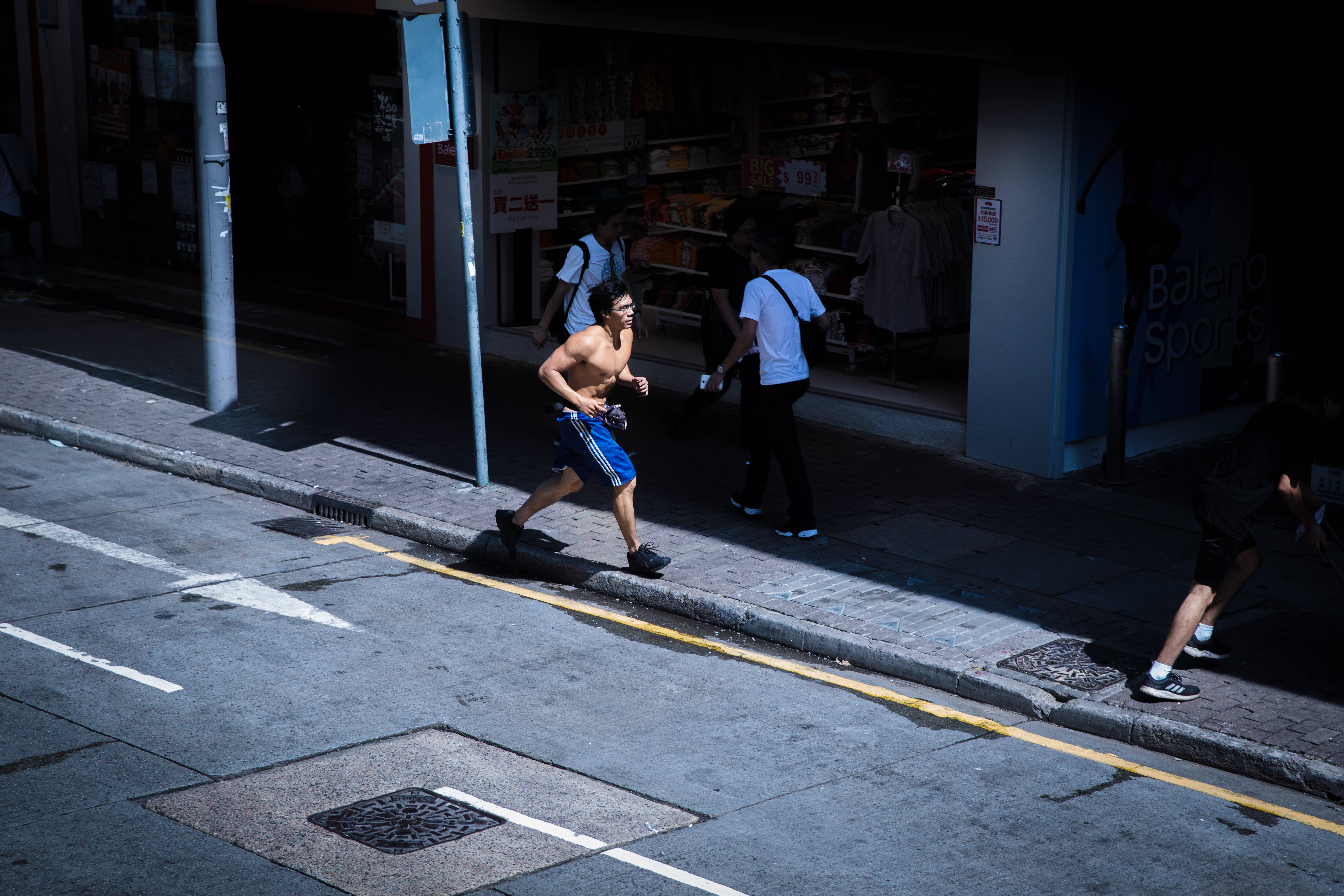 Runner, sunlit urban sidewalk, bustling city street, 5K Desktop Wallpaper