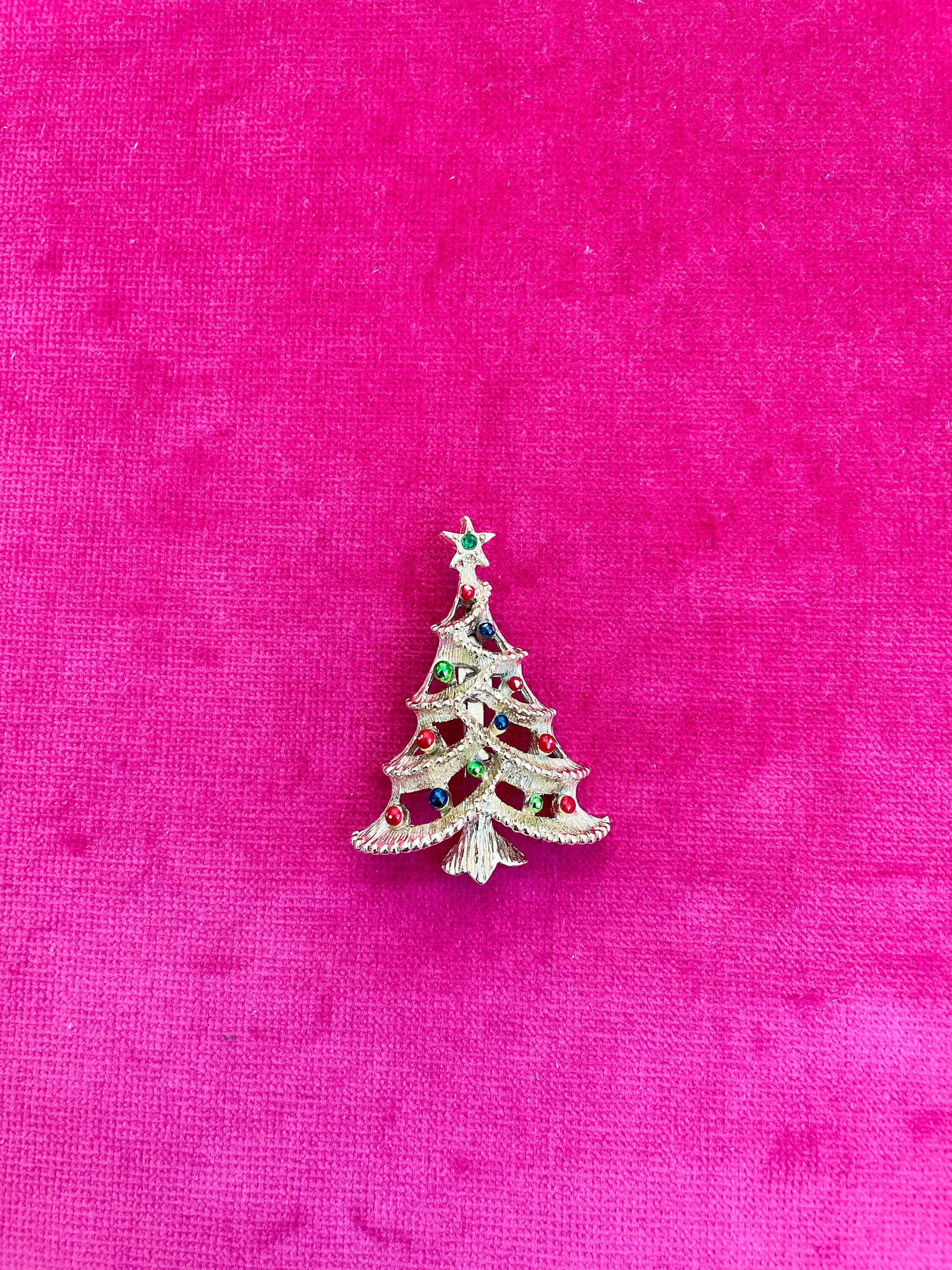 vintage gold Christmas tree pin, colorful gemstone ornaments, vibrant pink velvet background, 2K Phone Wallpaper