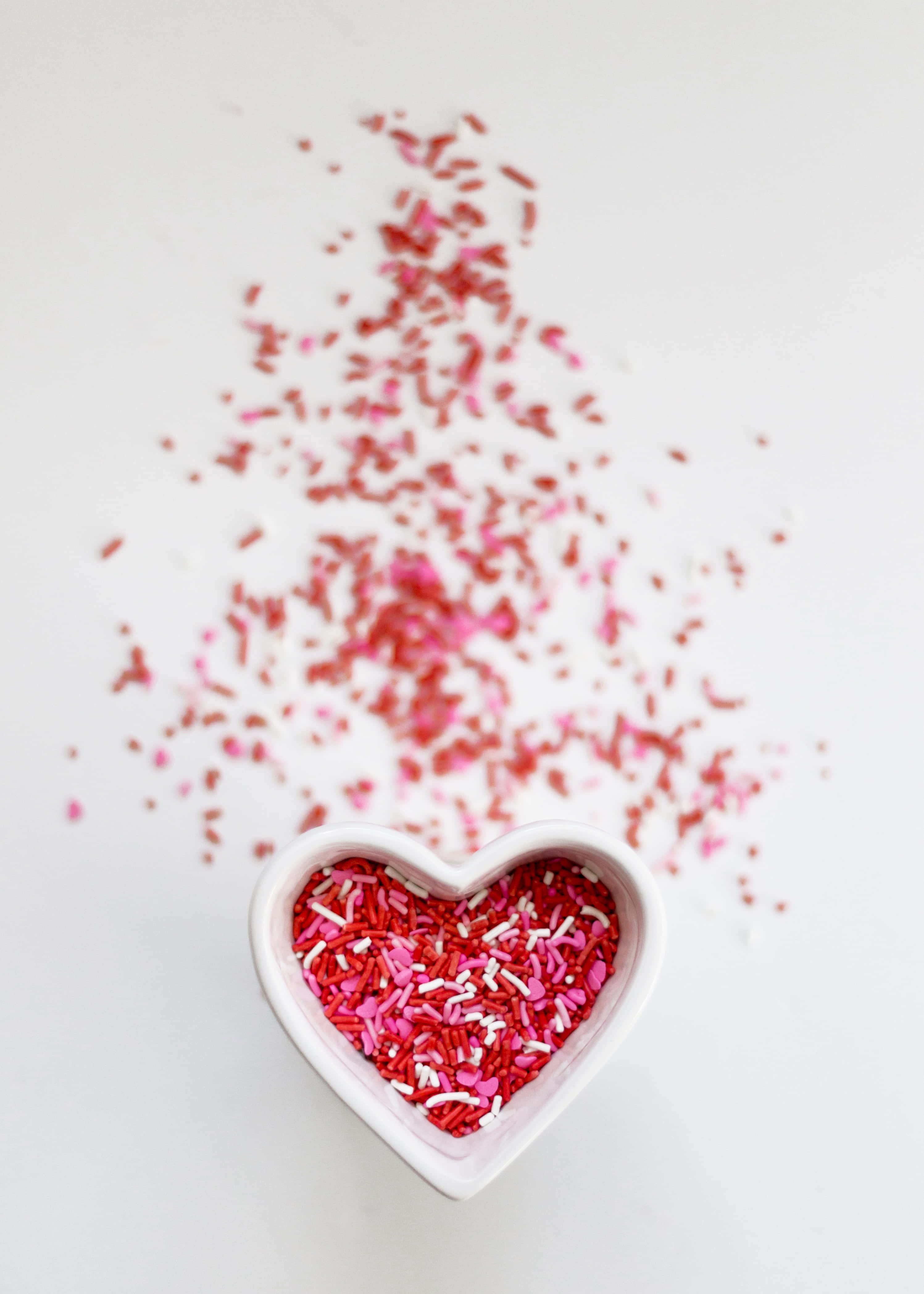 Rustic Valentine Day, white heart-shaped bowl, red pink and white sprinkles, 4K Phone Wallpaper