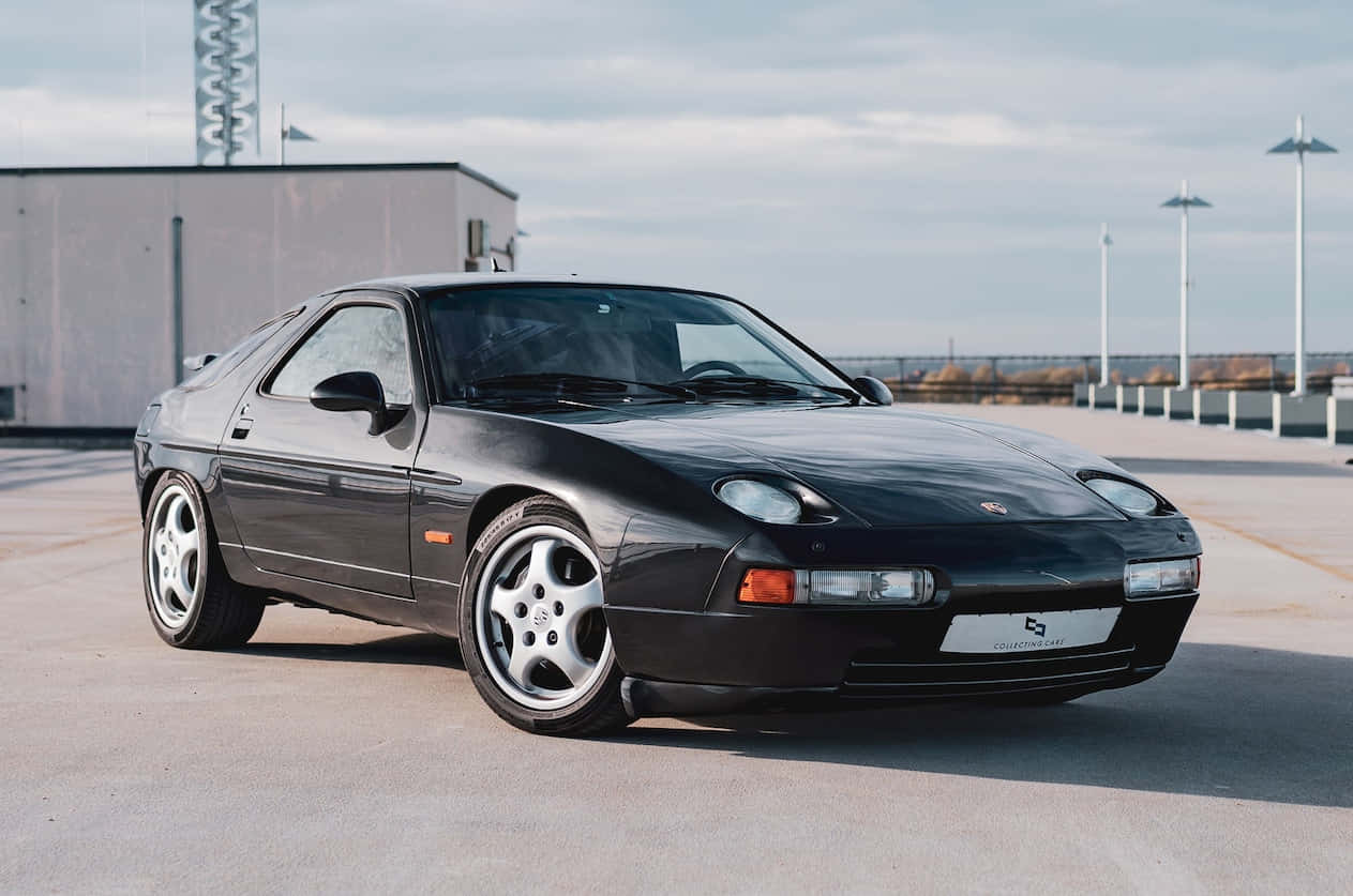 Porsche 928, sleek black, concrete lot, SD Desktop Wallpaper