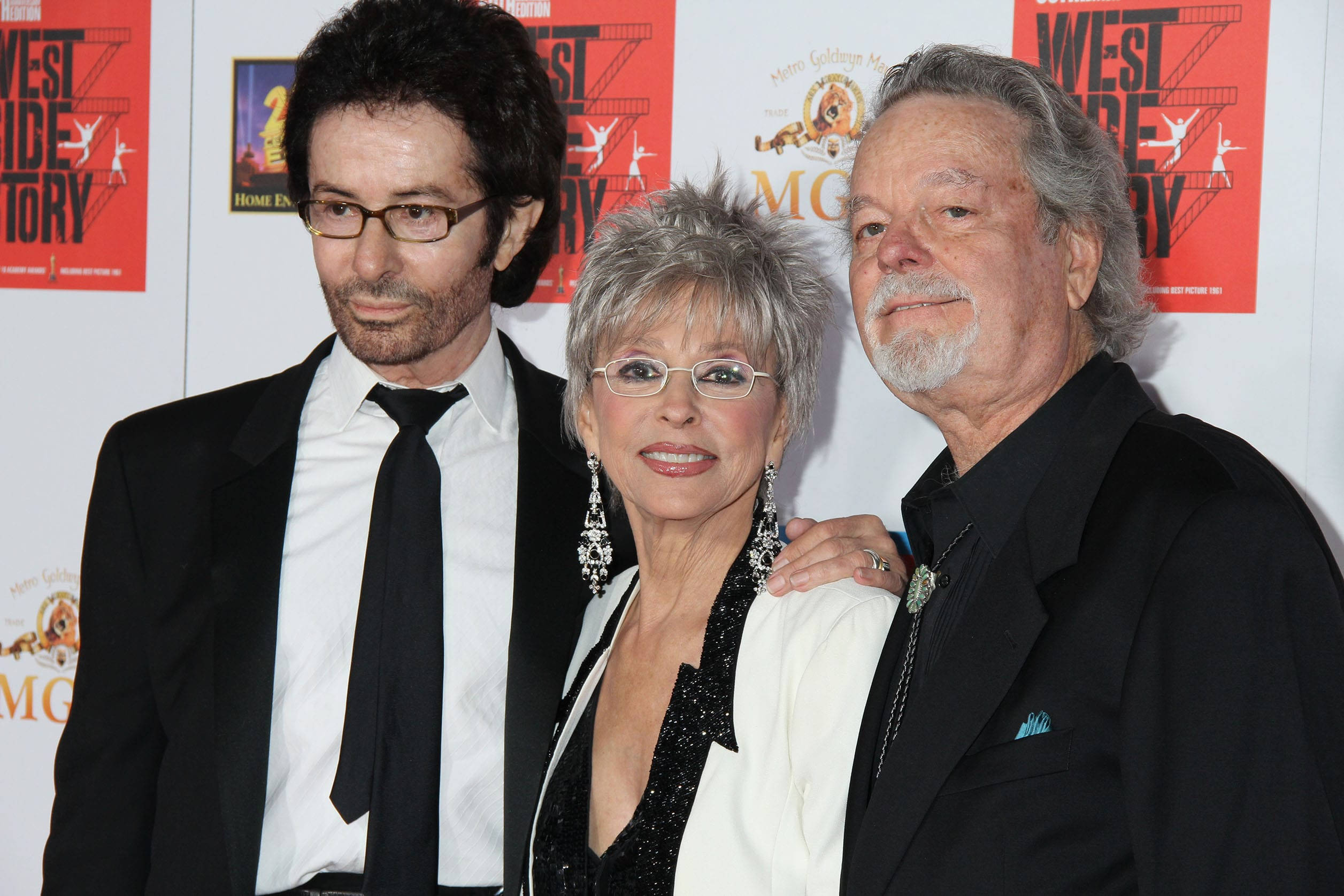 Three elegantly dressed celebrities pose together at a red carpet event with promotional banners behind them., Full HD Desktop Wallpaper