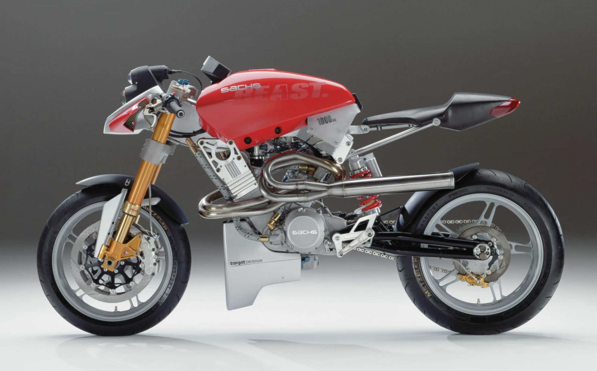 A sleek red and silver custom motorcycle with gold forks and exposed engine components stands in a studio setting., Full HD Desktop Wallpaper