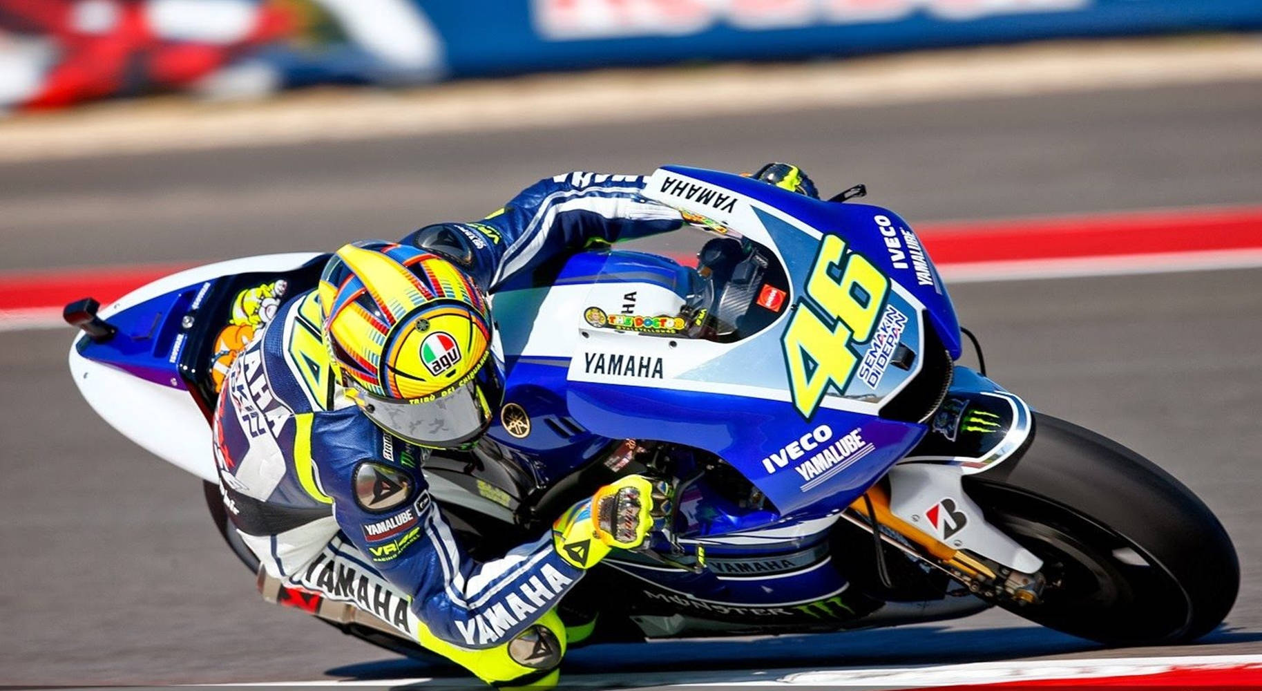 A motorcycle racer leans sharply into a turn on a blue Yamaha race bike during a high-speed track event., HD Desktop Wallpaper