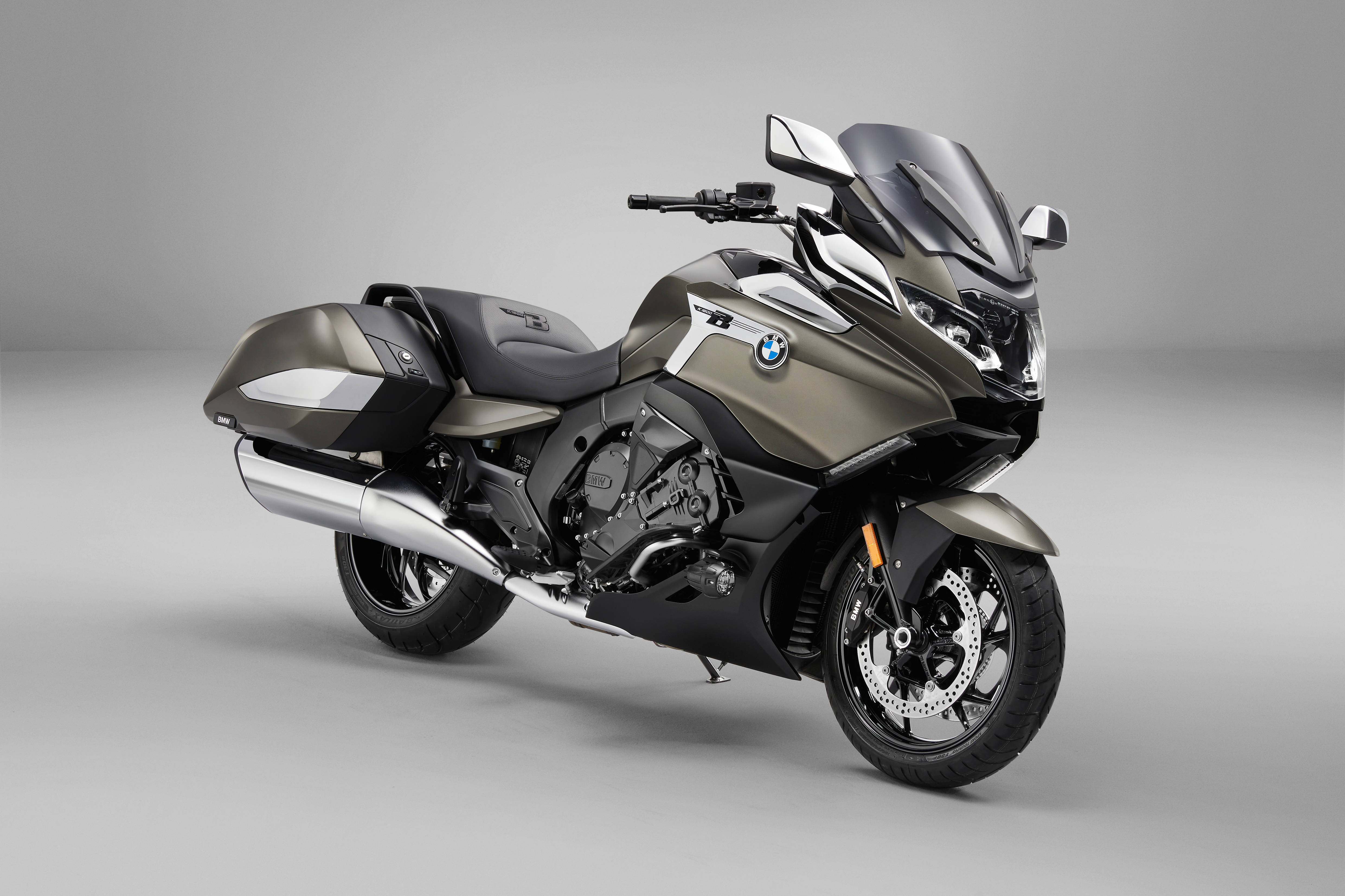 A sleek matte gray BMW touring motorcycle with chrome accents and large windscreen posed against a minimalist gray studio background., 4K Desktop Wallpaper