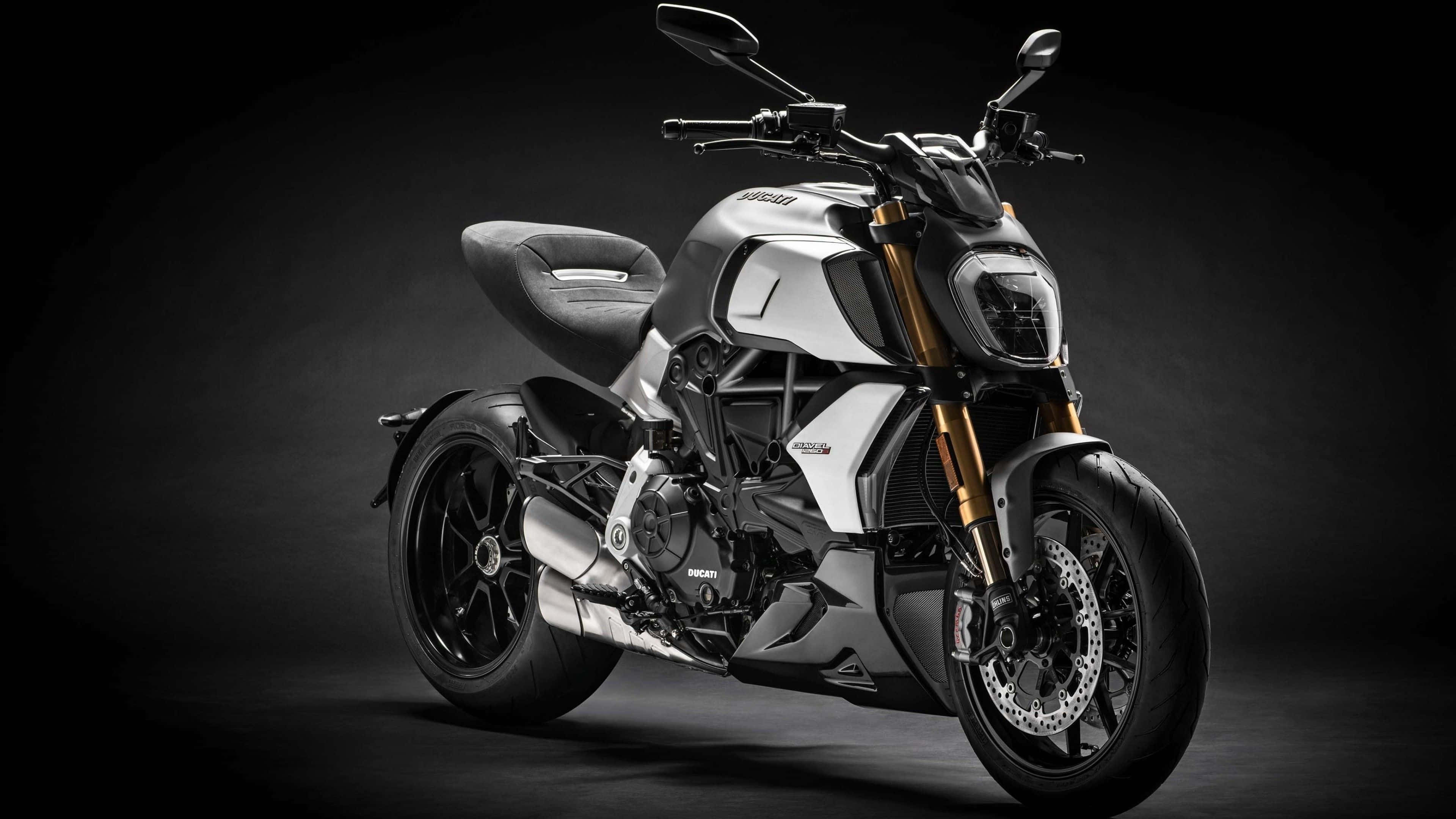 a black and white motorcycle is parked in a dark room, 4K Desktop Wallpaper