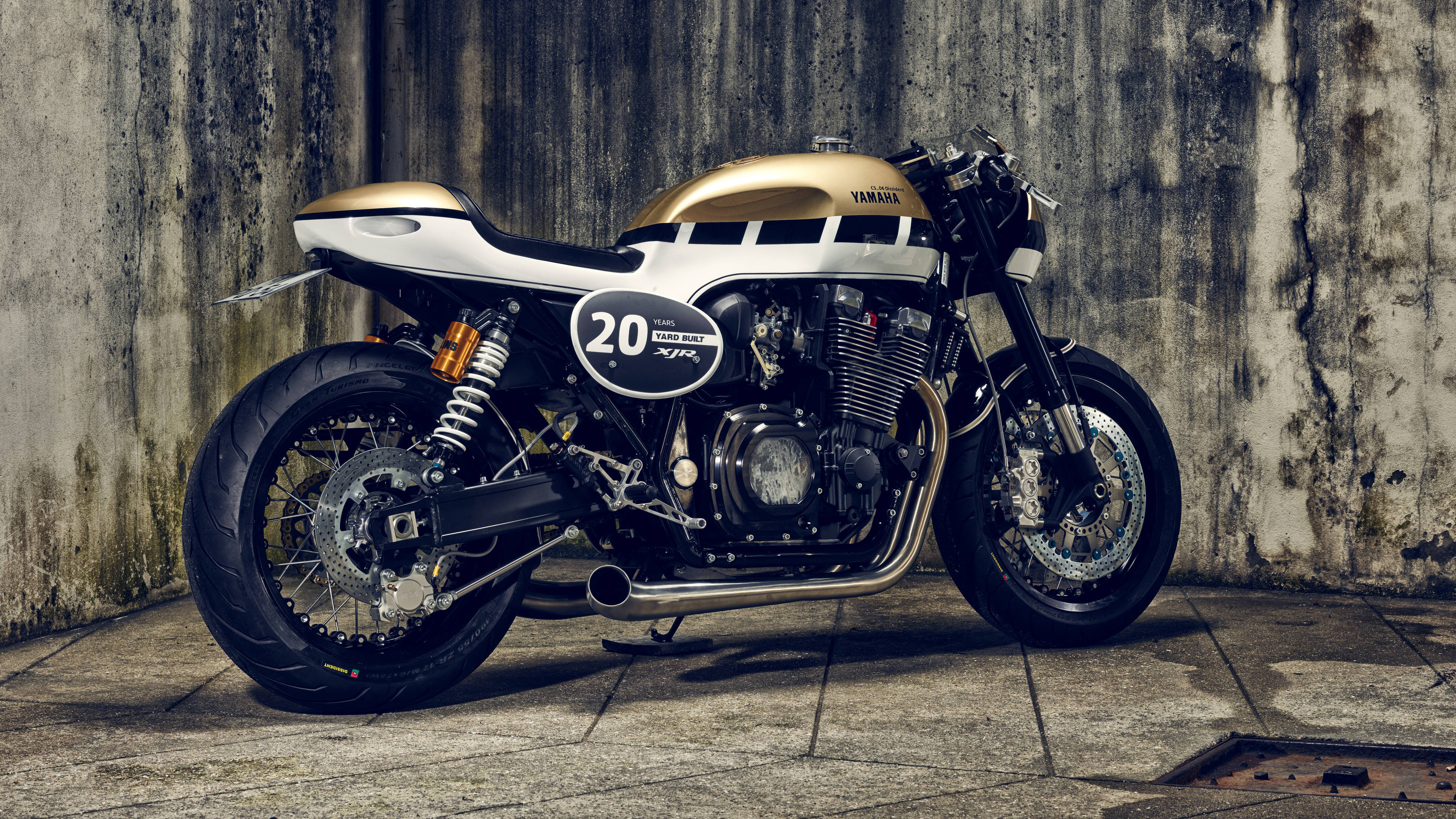 A gold and white Yamaha XJR motorcycle with racing number 20 parked against a weathered concrete wall., 4K Desktop Wallpaper