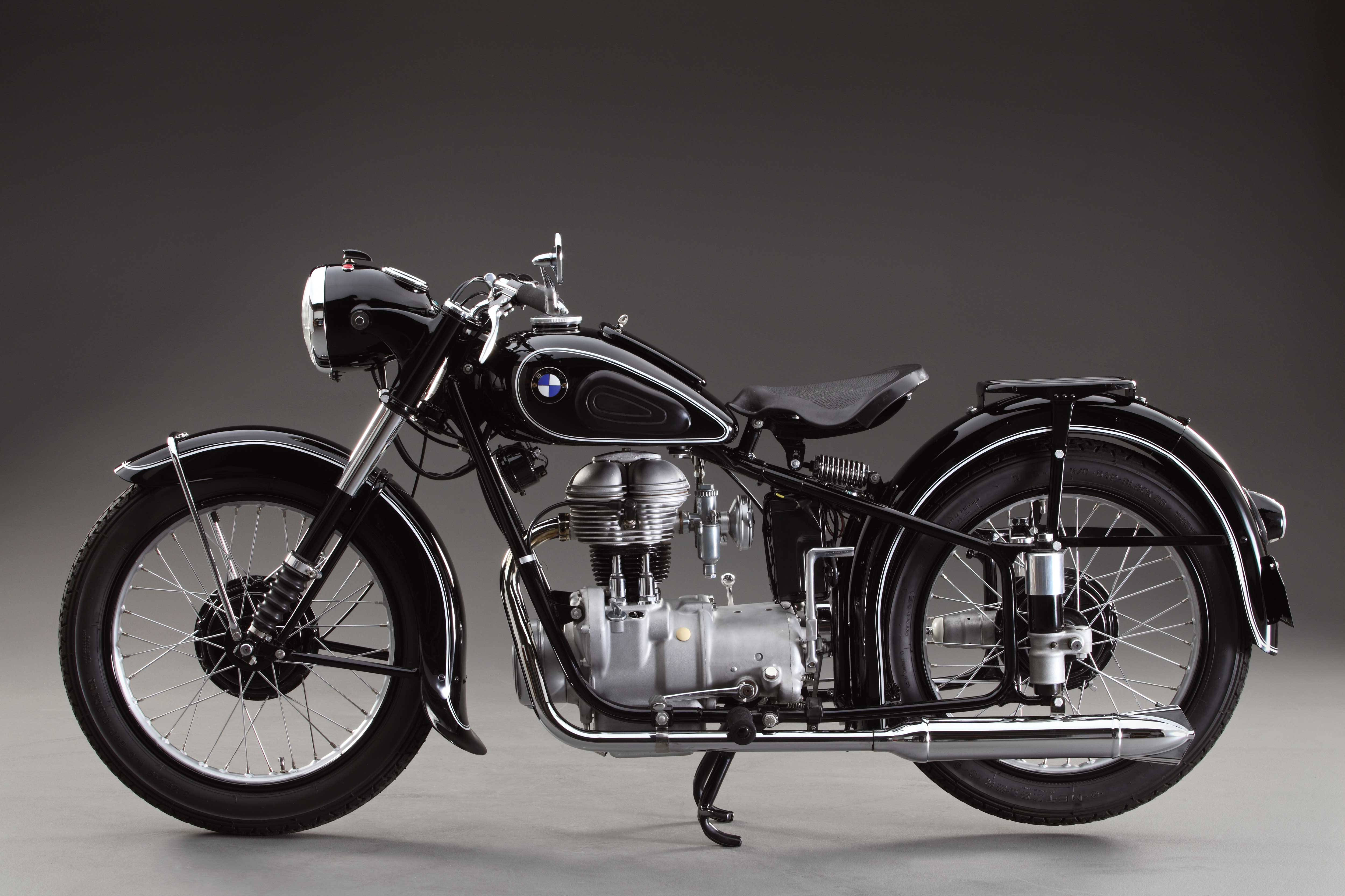 A sleek black vintage BMW motorcycle with chrome accents and exposed engine stands poised against a gradient gray studio backdrop., 4K Desktop Wallpaper