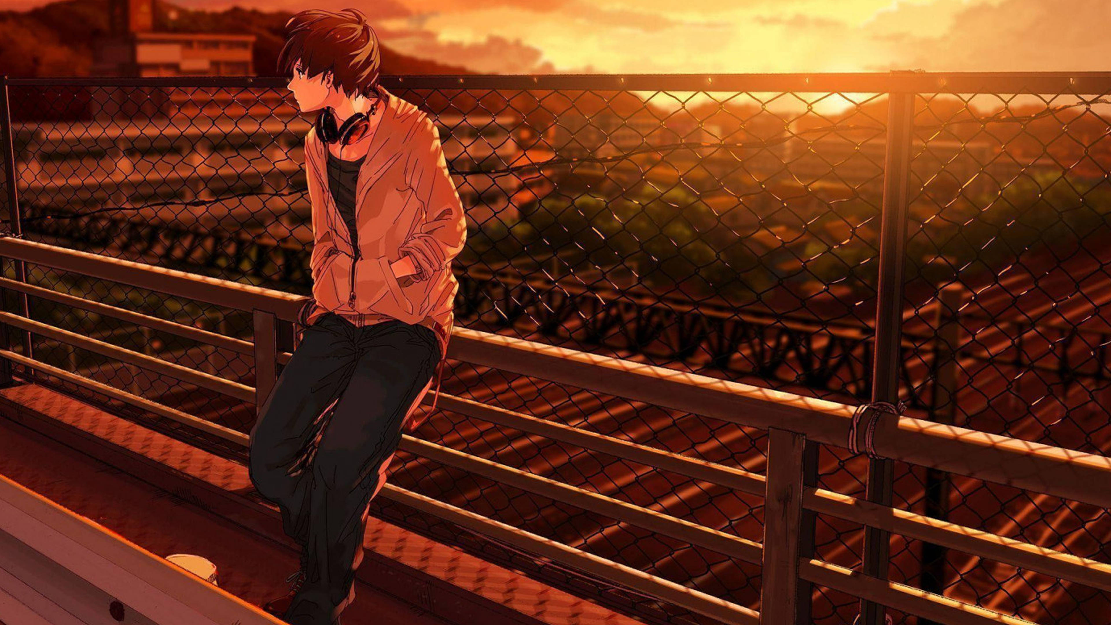 A young anime boy in an orange jacket leans on a railing at sunset, gazing over a cityscape bathed in warm golden light., 4K Desktop Wallpaper