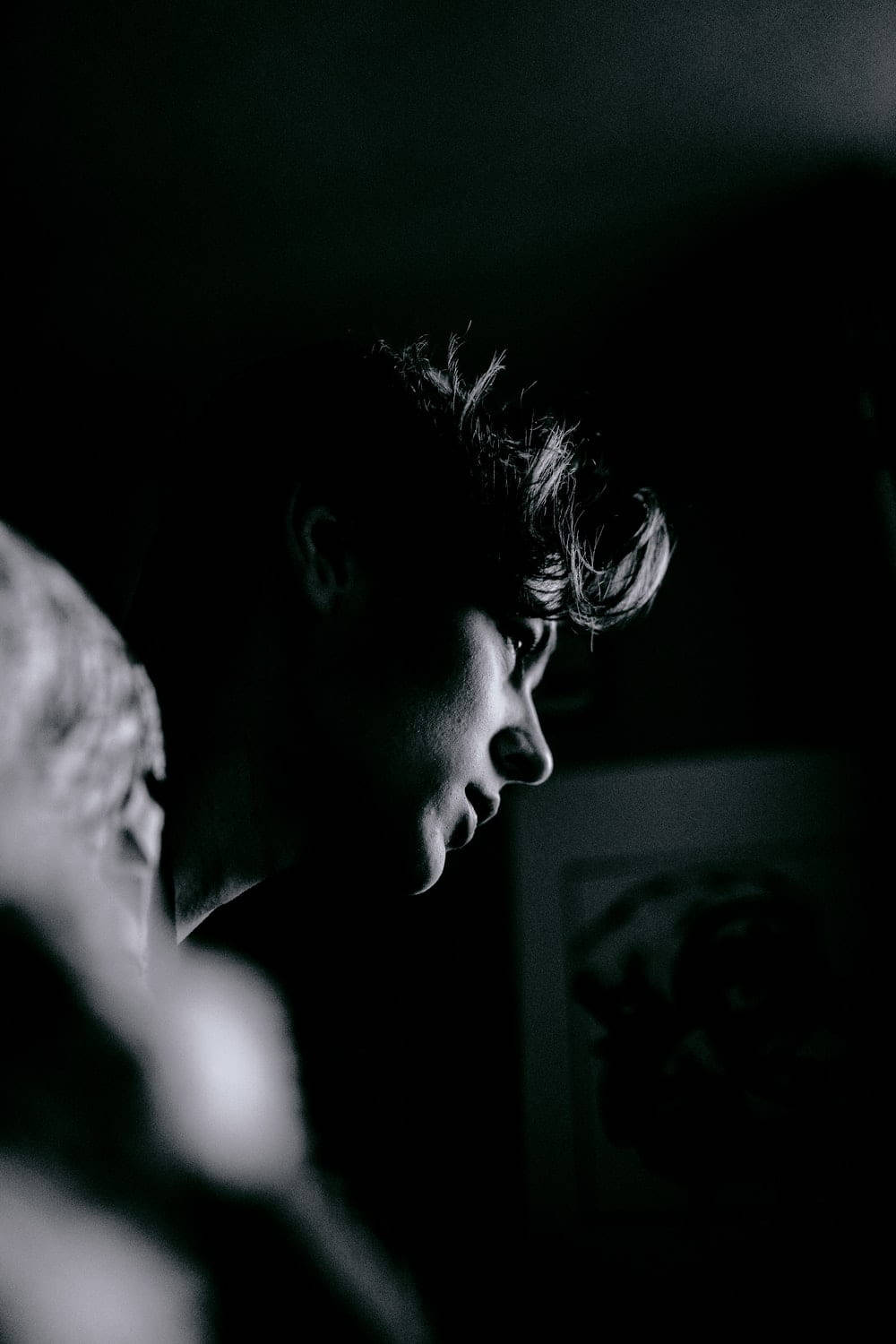 A person's face in dramatic chiaroscuro lighting with deep shadows and a single bright highlight on their cheek and hair., HD Phone Wallpaper