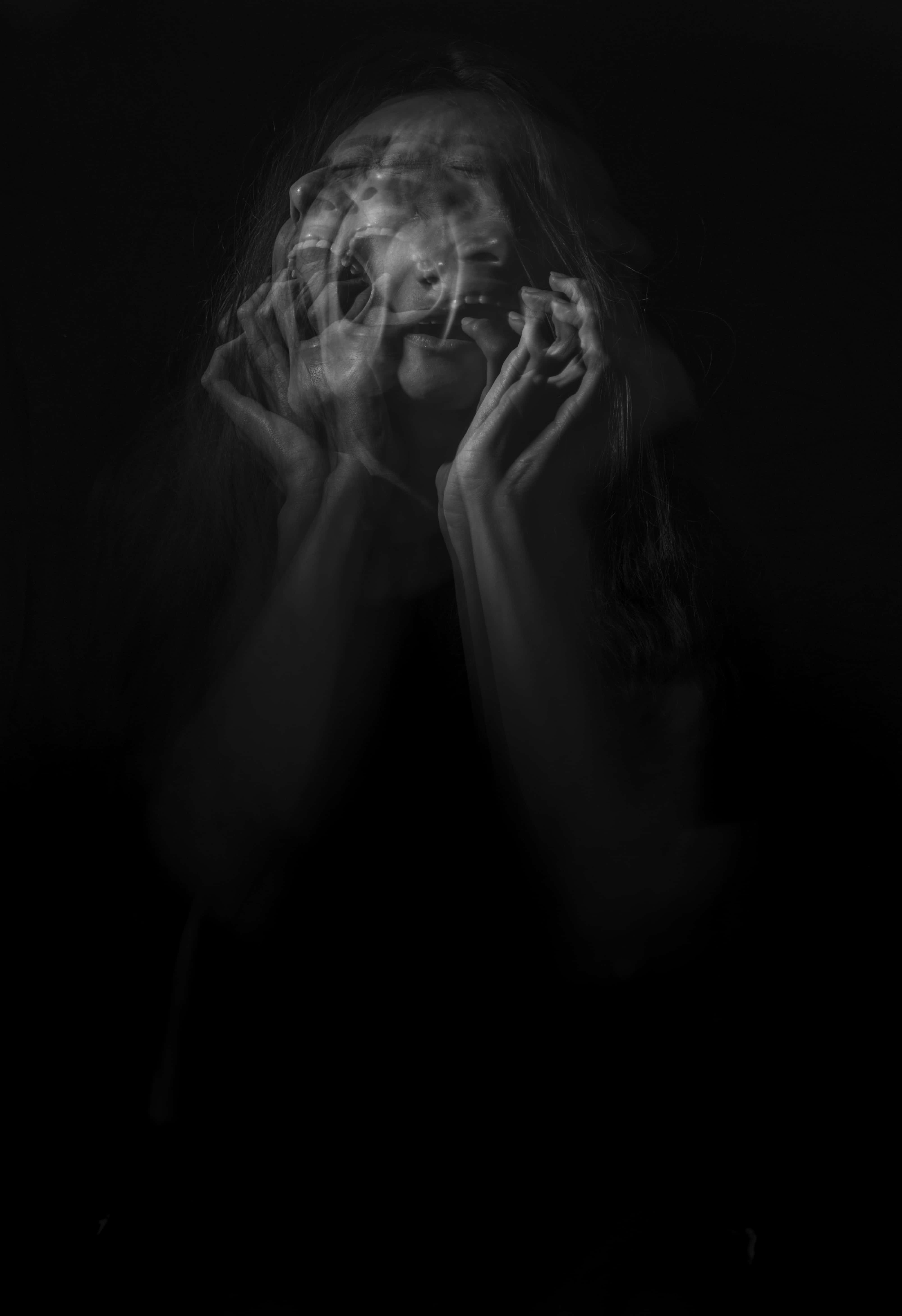 black and white portrait, woman with blurred ghostly facial overlays, held by her hands, 5K Phone Wallpaper